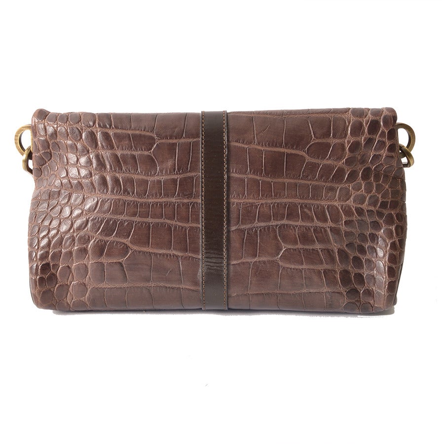 Exquisite handbag by Burberry Prorsum in brown leather with croc-effect and tarnished gold-tone hardware. Fold-over bag with gold-tone link chain strap, hook closure and horse detail at front. Bag opens up to one interior pocket featuring 