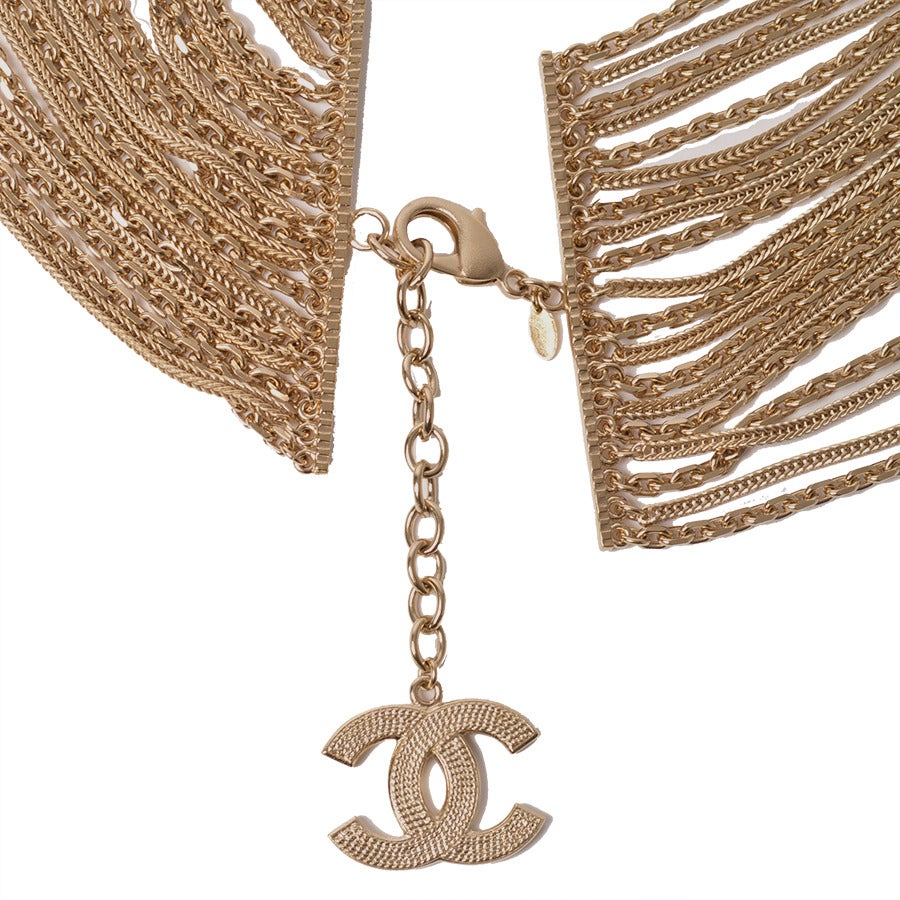 This light gold tone CHANEL chain waist belt is the epitome of of glamor.  Thirteen identical strands divided into 5 sections with a metal bar to give a hint of drape while reinforcing shape.  Stunning when contrasted with jeans or as an evening