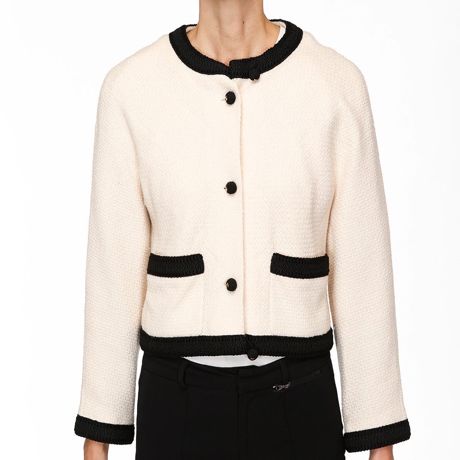 Chanel’s signature bi-color jackets are always in demand. The light weight “mini popcorn-like” tweed in ivory is beautifully contrasted with a 1” embroidered black trim along the neckline, cuffs, pockets and hem.  The small black ball shaped buttons