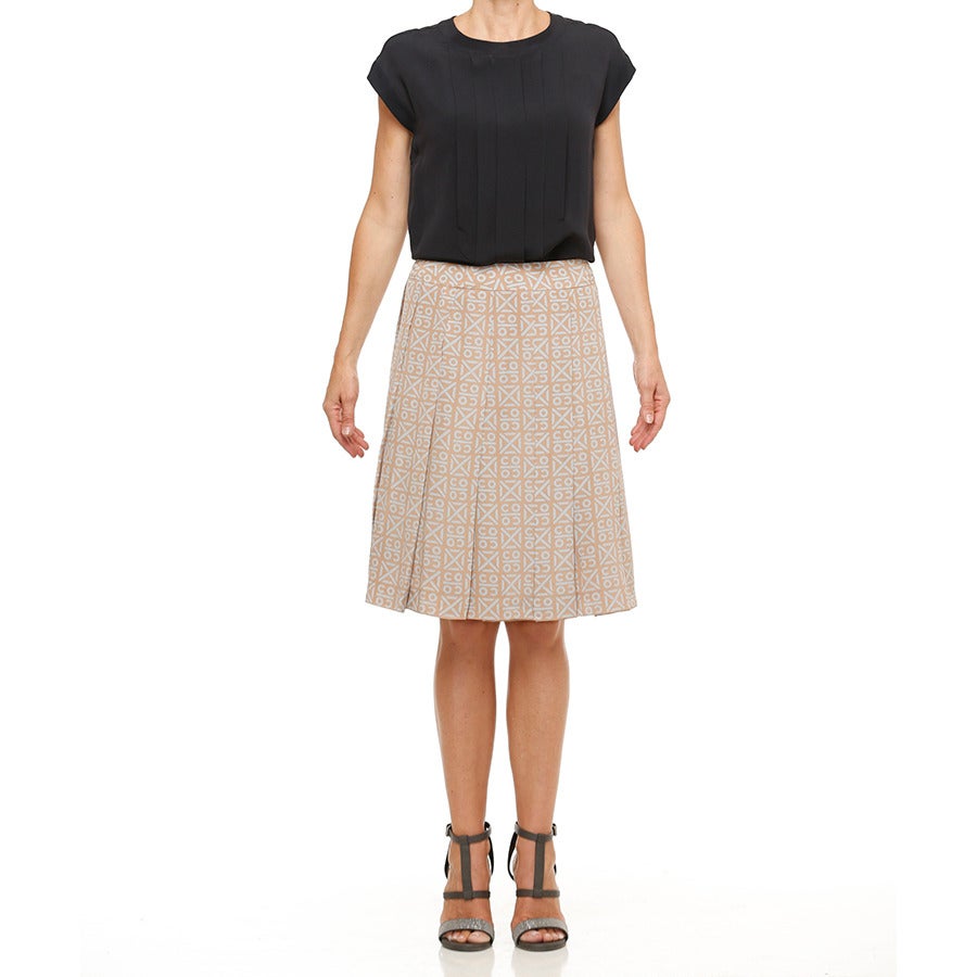 A beautiful CHANEL skirt which features 13 soft wide 2.5” pleats in a Coco print of  taupe and pale aqua. The built in crinoline inserted between the printed silk  and silk mesh lining gives extra body to this feminine silhouette, especially when