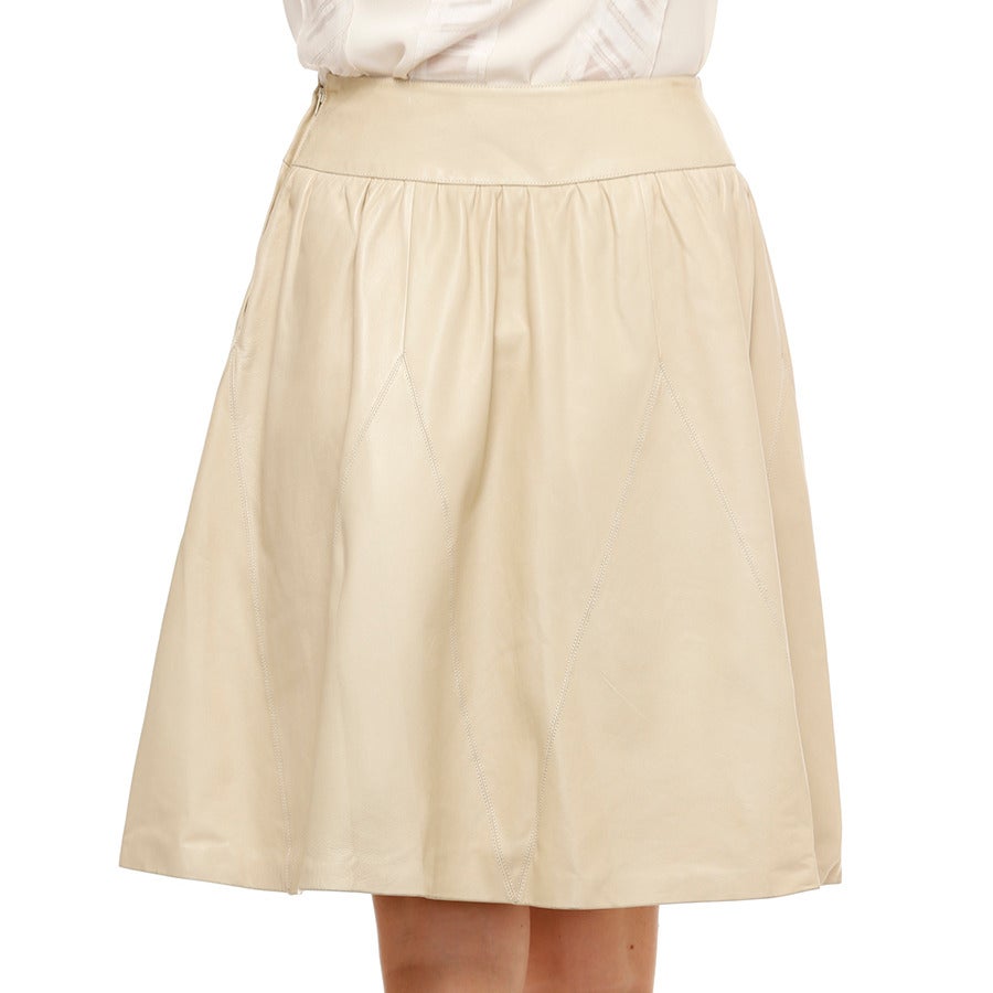 A breathtaking CHANEL skirt in ivory lambskin exudes luxury in material, color and silhouette.   A complex construction, the drop waist with soft “baby-doll” gathers from 6 triangular panels which fall and merge with 6 triangular panels rising from