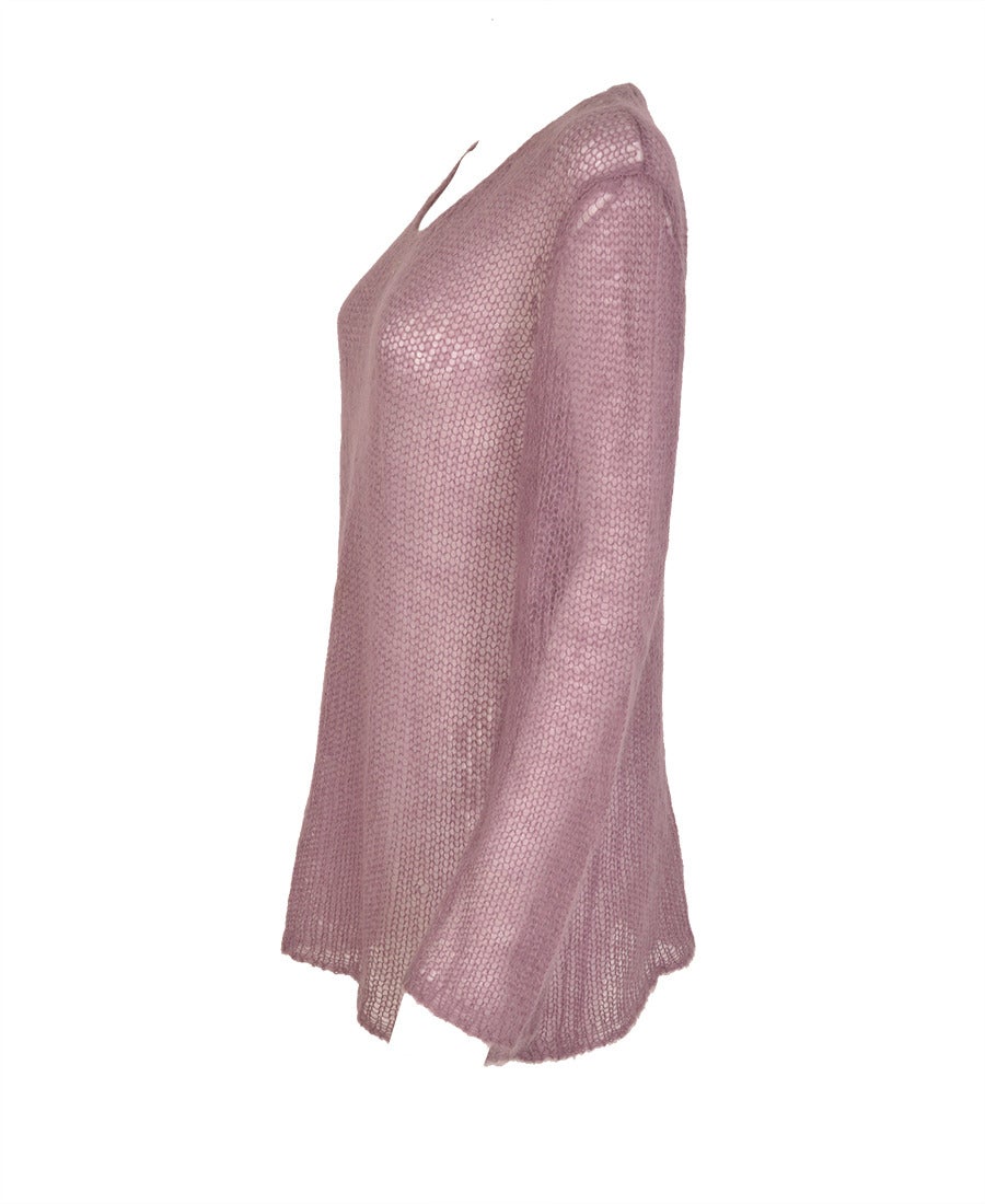 This Chanel v-neck knit in soft lilac coloured mohair has an open stitch which exudes an ultralight ephemeral quality.  The soft V neckline features  a small silver metal CC.  Great with grey slacks or jeans of any color. 

- Material: 70% Mohair;