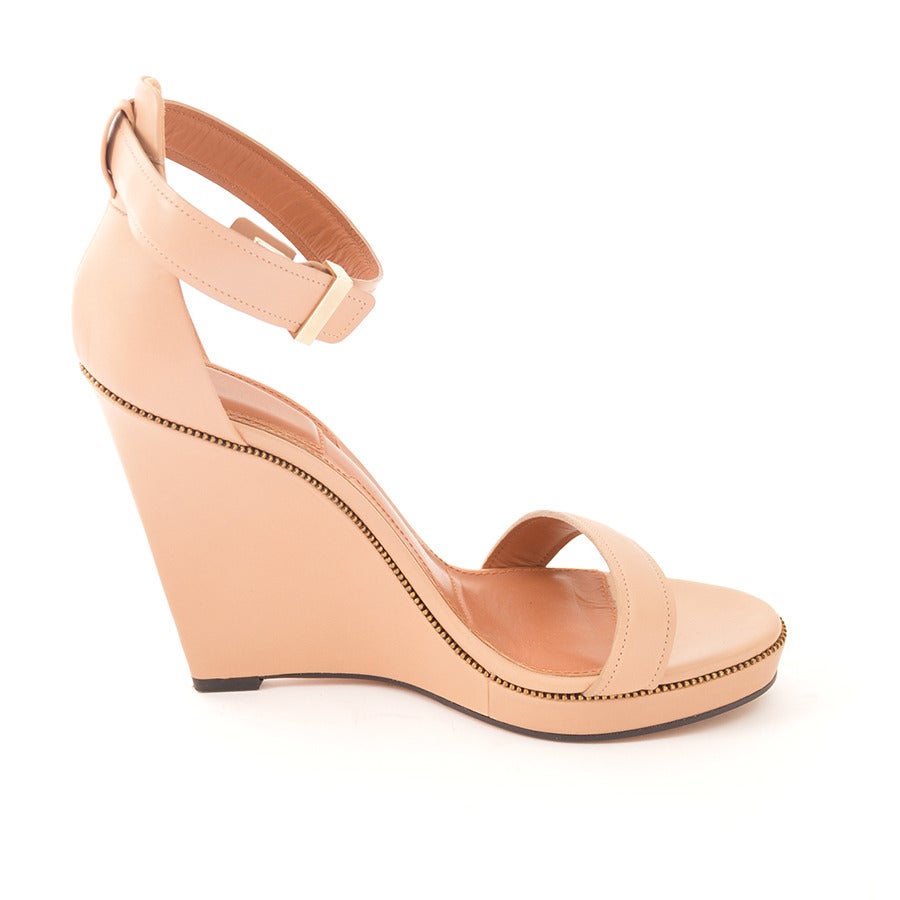 GIVENCHY smooth calfskin leather open toe sandal with thin band at toe and brass-tone zipper-style trim. Closed back and posted adjustable ankle strap with hidden buckle closure. Covered, sculpted wedge. 
- Size 39
- Padded footbed. 4.25