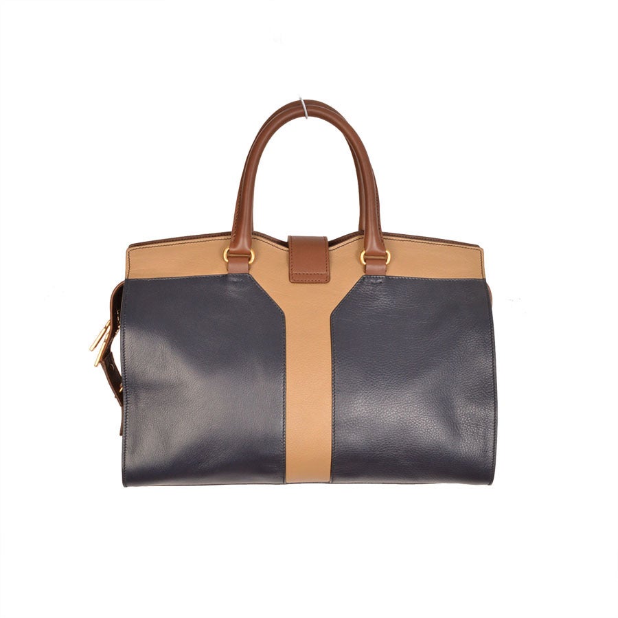 YSL, Yves Saint Laurent CHYC navy/beige/brown leather handbag with tubular handles, zip compartment closure, gold toned Y buckle, subtle Y outline, magnetic button fastened strap. One interior zip pocket and two slot pockets. Cotton lining. Gold