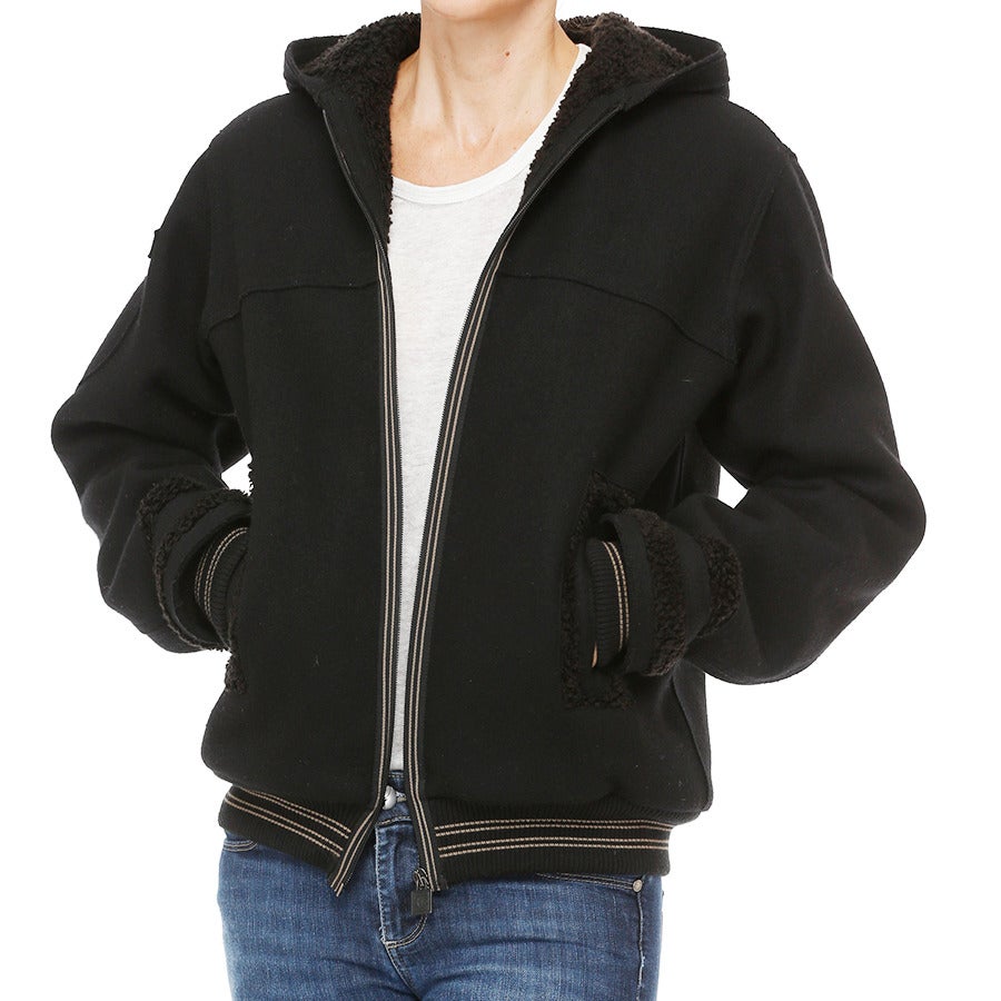 The bomber jacket is part of the Chanel “Sport” Collection. This popular silhouette features matching black shearing-like texture on lining of hood / torso & on trim of cuffs & side pockets.  Knit hem & cuffs to keep in warmth. Double striped