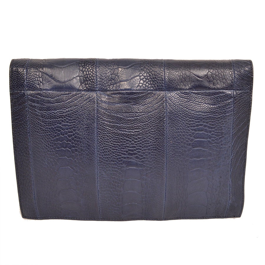 YSL, Yves Saint Laurent navy blue croc-embossed Y envelope clutch. Features navy croc-embossed pattern and a front Y-tab closure that opens up to a luxurious matching blue silk lining. Perfect for day or night, it's a great accessory for any fashion