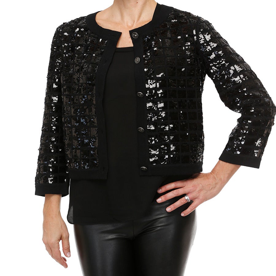 A beautiful Chanel evening cardigan in cashmere features a square quilted pattern encrusted with thousands of black sequins.  A seasonless piece that is perfect over the shoulders  as the evening cools during a summer dinner or as a cover up over a