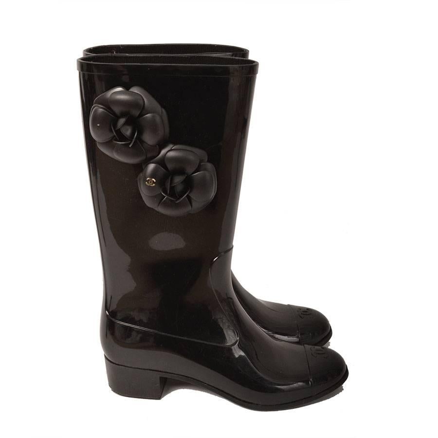 Chanel Black Rain Boots - Size 37 (US 7) with gold metal CC logo on black camellia flowers and CC logo on cap toe.

- Size: 37 (US 7)
- Measurements: Boots height: 11