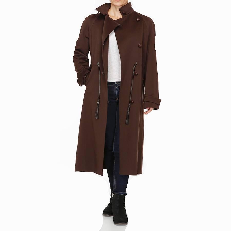 A stunning and timeless rich brown long wool coat by Yves Saint Laurent. A beautiful slim silhouette with brown leather tassel drawstring waist. Five round brown leather woven buttons down front with brown leather loop fasteners. 2 side pockets also