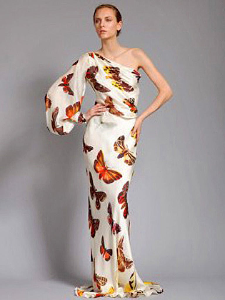 Alexander McQueen's 2005 stunning one shoulder bias cut gown fashioned in a silk butterfly hand painted pattern. Bishop style sleeve drapes loosely and is cuffed tightly with covered buttons at wrist. Fully lined. Side zipper closure. Butterflies,