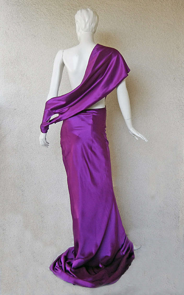 Alexander McQueen violet silk charmeuse bias cut gown fully lined. One shoulder grecian style features panel construction; drape from back of shoulder strap that wraps around wrist, fully lined. Concealed side zipper closure.

Size: 44; bust: to