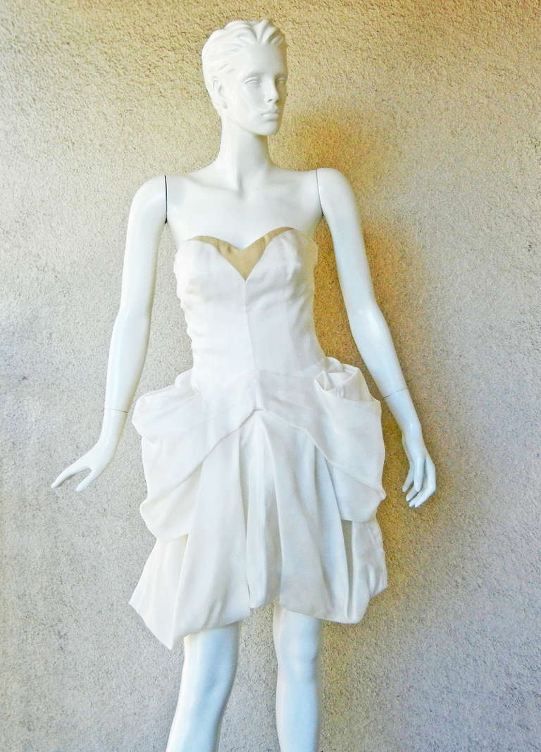 Alexander McQueen's pre death 2008 Collection strapless bustier pouf dress.  Fashioned of ivory silk organza draped in soft cascading folds creating high styled pouf skirt.  Corset interior with double zipper closure.

Size: 42;  bust: to 34