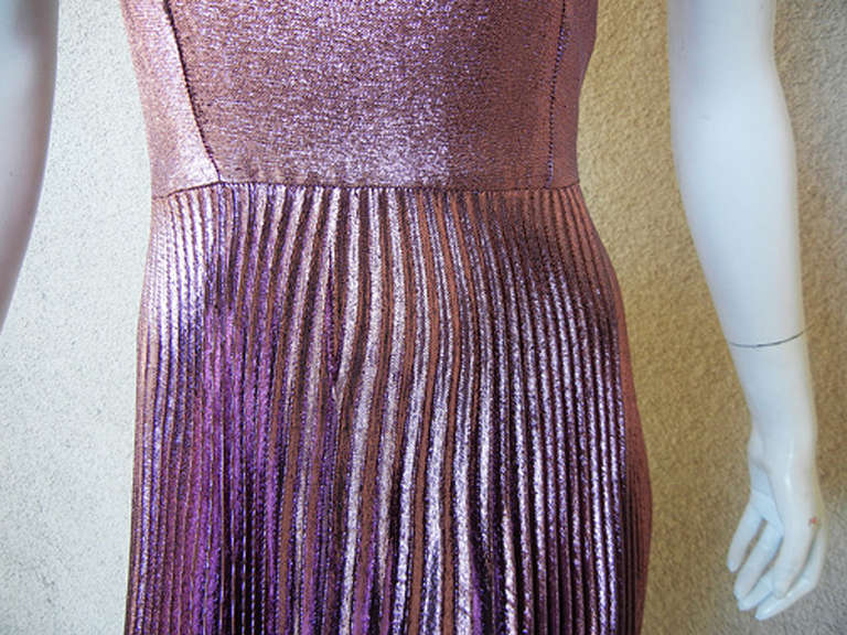 Vestido de seda rosa frambuesa de Christopher Kane. Presenta sisas caídas, espalda ligeramente redondeada, falda con pliegues en acordeón y bajo hundido. Parcialmente forrado. Cremallera trasera oculta. Impresionante diseño que combina el estilo