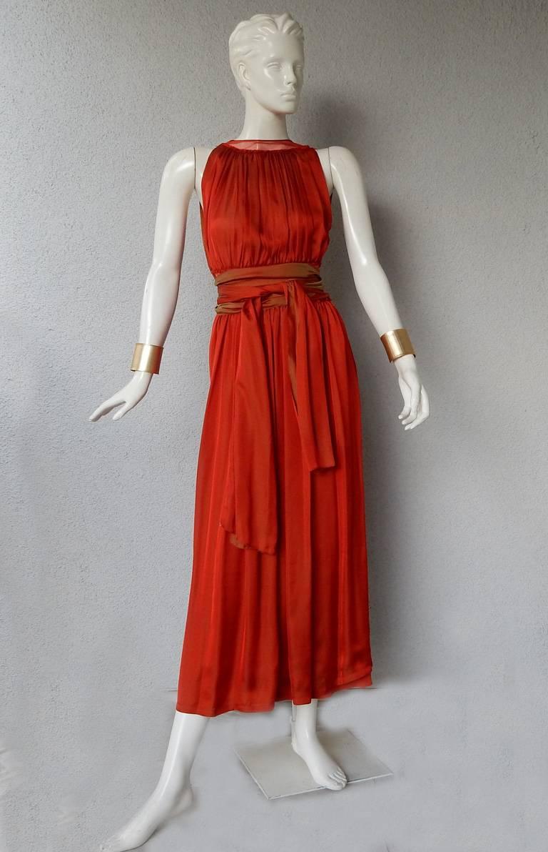 Jean Paul Gaultier diaphanous silk maxi  dress.  Fashioned of rich iridescent cayenne silk with pleated bodice, sheer net waist, flounce hem and button closures at shoulder and side.  Also included separate half underskirt.  Long double wrap obi tie
