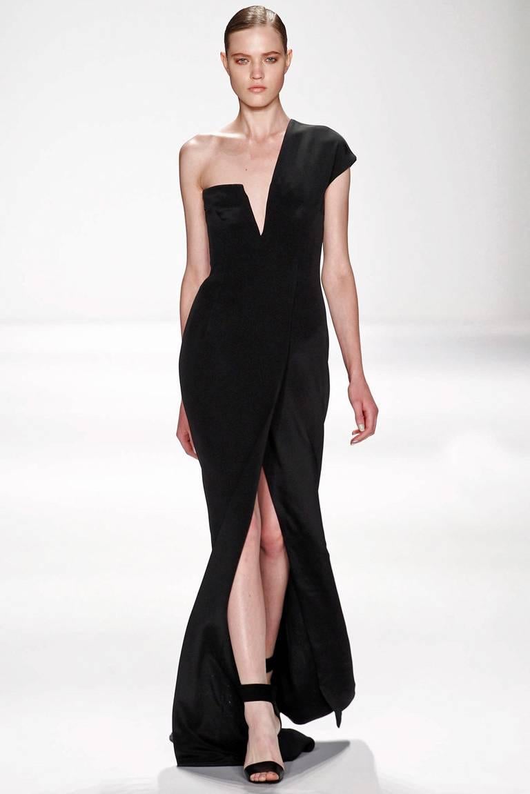 KaufmanFranco black silk gown designed with stunning visual appeal.   Boasts lined and padded interior bonded bodice with side zipper closure.  Lightly draped skirt with high front slit. Back features inverted V nude net panel.  Dress is identical