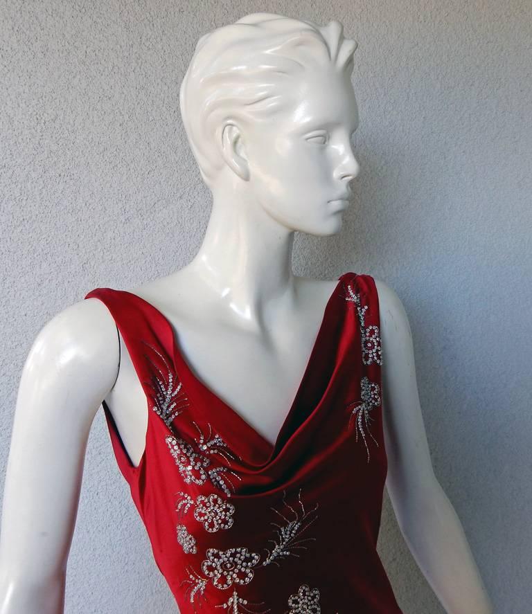 Ravishing red silk gown by John Galliano.  Circa 2004.   Hand embroidered bias cut dress with tiny side covered buttons.  Dramatic drop back treatment.  Lined.  An excellent representation of the Galliano design and tailoring.

Size: fr 40: bust: