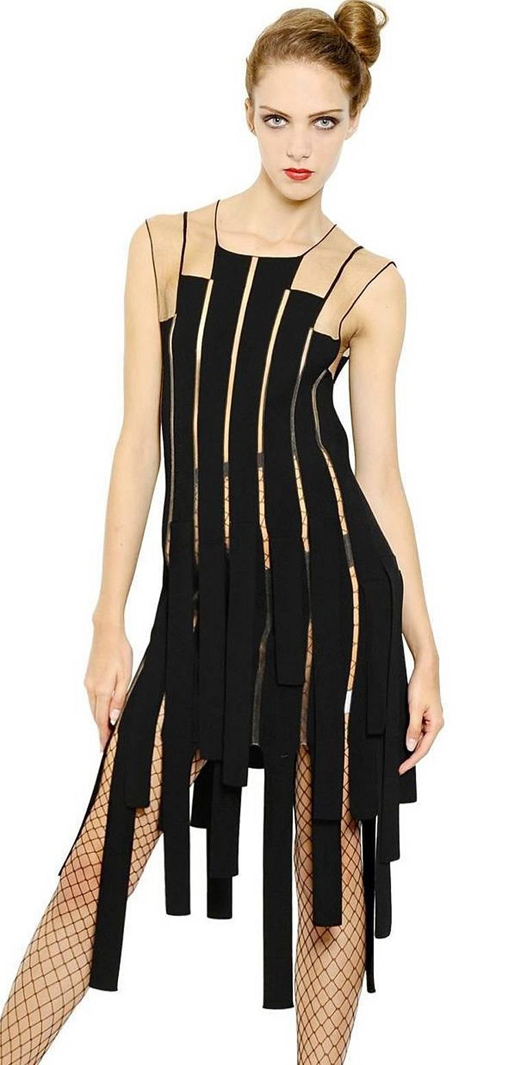 Jean Paul Gaultier body hugging ribbon dress fashioned of rayon and poly with a bit of stretch.   Features nude net look shoulder treatment extending into uneven strips down the body of the dress.  Simple over head easy slip on. 

Size: XS;  Bust: