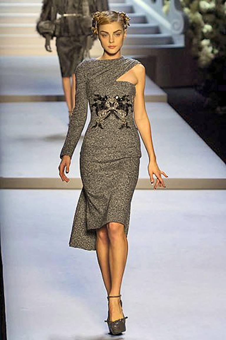 This 2007 Dior collection by John Galliano celebrated the 60th-year-anniversary of the Christian Dior glamourous fashion legacy.   

One shoulder embroidered tweed wool dress with a 40's style bustle reflects the draping and style of the New Look