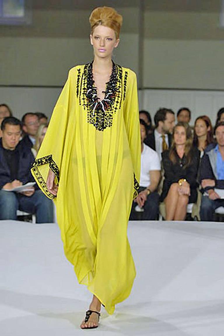 Exquisite lemon yellow silk hand pleated caftan by Oscar de la Renta. Heavily embellished hand beaded neckline and wrists in jet black beads.  Designed with inset sleeves.  Pleated detail in front and back. Offered brand new and perfect for dressy