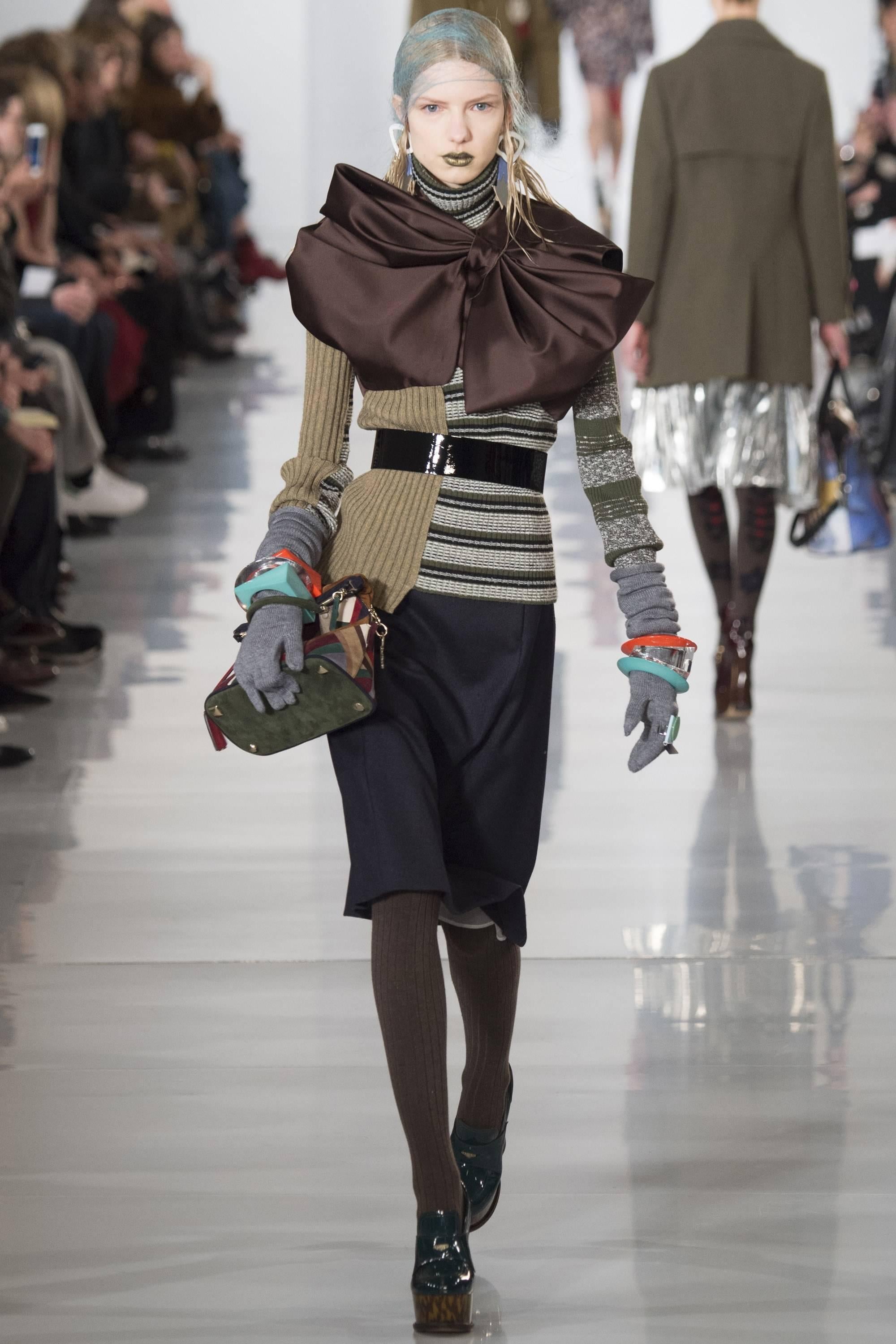 Stunning Masion Margiela mixed media asymmetric sweater adorned with large bow at shoulder.  As seen on the runway (see photo).  One of the best Margiela sweaters designed by John Galliano.
 
Fashioned of a soft wool, poly, viscose, and acrylic with