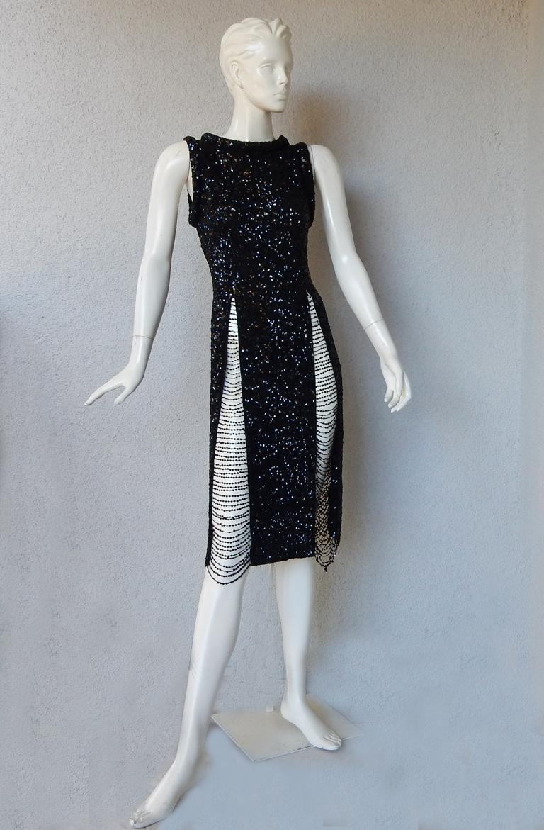 Schwarzer Strick von Jean Paul Gaultier, überzogen mit Pailletten auf dem gesamten Körper des Kleides.  Die 4 verlängerten, oberschenkelhohen Schlitze bieten einen fabelhaften, sexy Look mit handgenähter Paillettenkette.  Der Stil ist ein subtiler