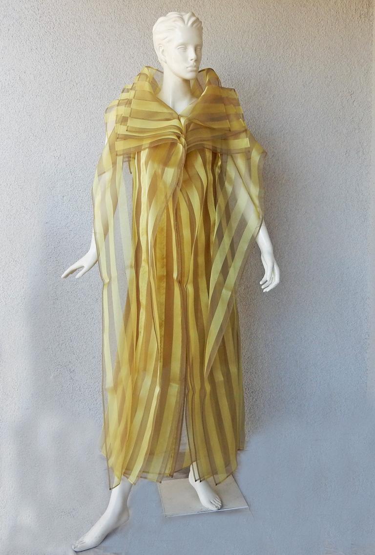 The A/W 2009 Issey Miyake collection captures a fresh distinctive look utilizing the designer's  signature origami and pleating techniques.

Asymmetric long caftan style dress fashioned of marigold silk and poly stripe pattern overlaid on matching