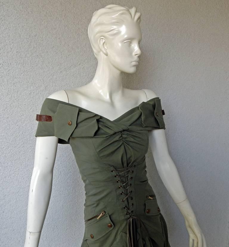 House of Dior 2003 military style dress by John Galliano.   Features a unique perspective  of military fashion including details such as military zipper pockets,  ammo holders, etc.   Fashioned in army green weighty cotton.  Lace-up bodice boasts a