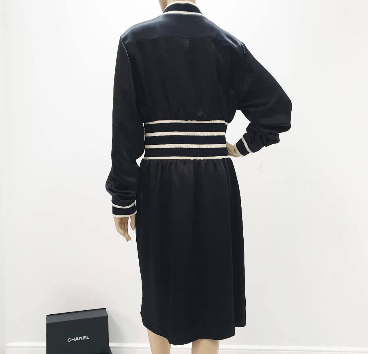 Dieses zeitlose und schicke Midikleid aus schwarzem Satin mit Streifenmuster von Chanel aus dem Jahr 2017 ist ein Must-have für jede Modebegeisterte.

In sehr gutem Zustand, strahlt dieses Kleid Raffinesse und Eleganz aus.

Es wurde mit viel Liebe