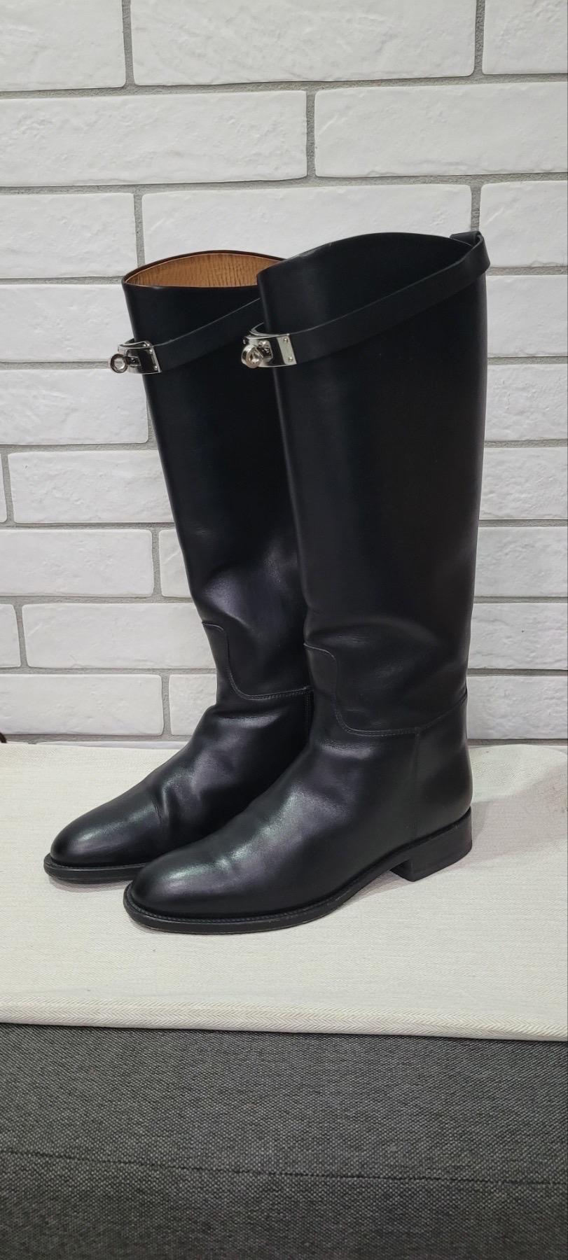 Botas de salto Kelly HERMES 
talla 37 en Negro. 
Estas impresionantes botas de montar están confeccionadas en lujosa piel de becerro lisa de color negro y caen justo por debajo de la rodilla. 
Las botas tienen una correa superior que se sujeta con