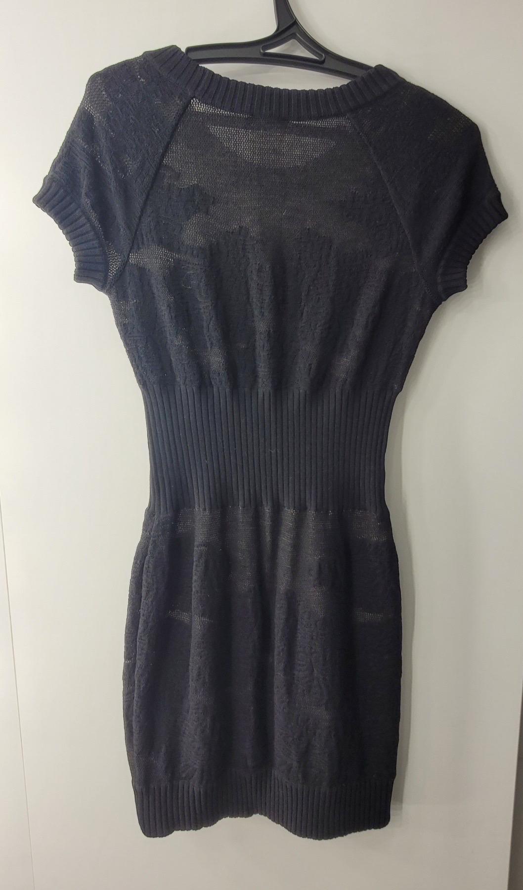 Dies ist eine authentische Chanel schwarze Wolle Kleid in sehr gutem Zustand.
 Es hat kurze Ärmel und CC-Knopf-Akzente.
 Perfekt für jeden Chanel-Liebhaber!
Sz.40
Sehr guter Zustand