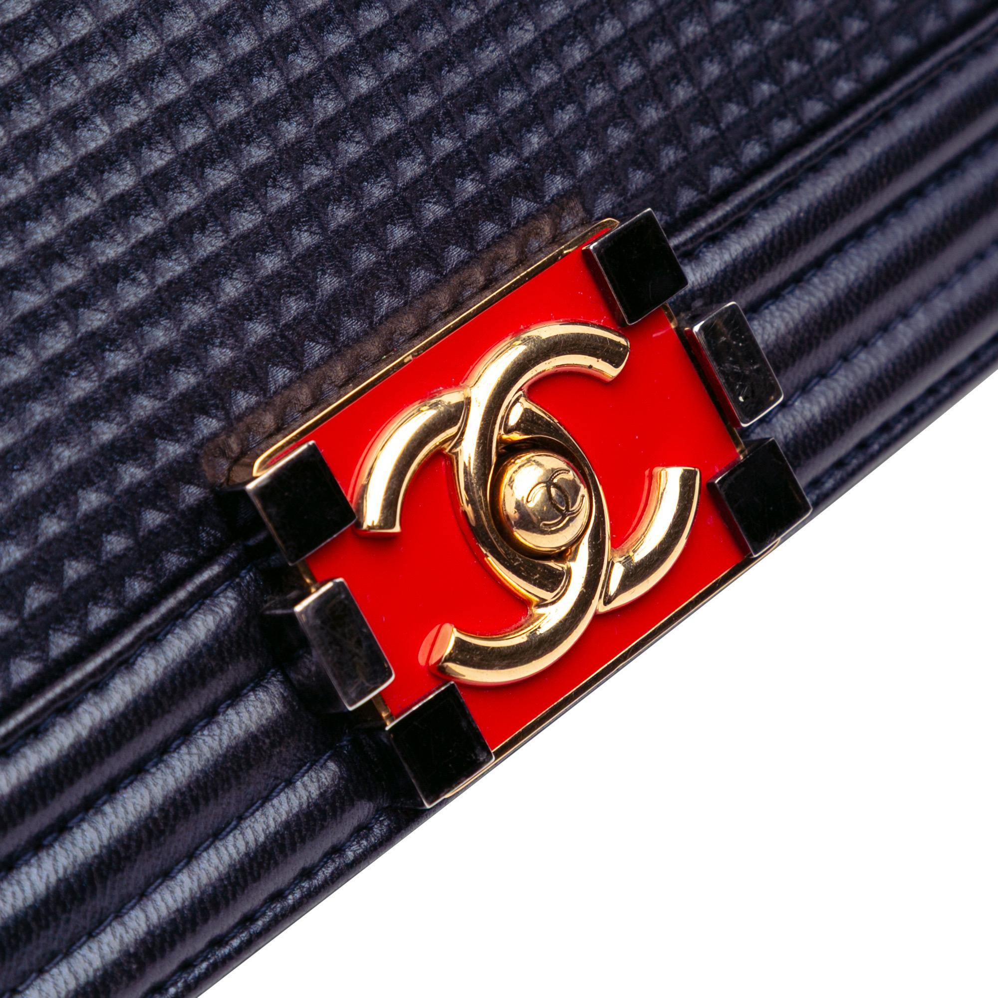 Diese atemberaubende Chanel Navy Medium Lambskin Embossed Cube Boy Flap Tasche ist die perfekte Ergänzung für die Sammlung jeder modebewussten Frau! Das luxuriöse Lammleder und das einzigartige, geprägte Würfeldesign machen diese Tasche zu einem