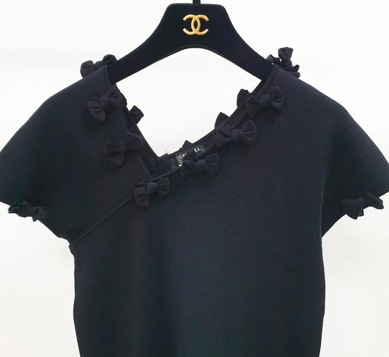 Design:
- Maglia nera con maniche a cappuccio.
- Scollo a V decentrato.
- Dettaglio fiocco.
- Pullover.
- Placca con logo CC sul fianco sinistro.

Fabrice: 82% Cotone, 18% Poliammide

Ottime condizioni.
L'appendino non è incluso.