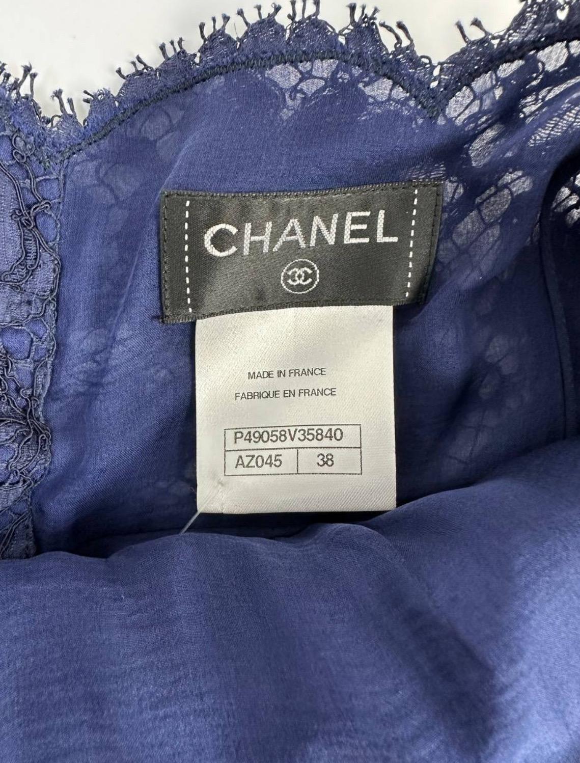Eleva il tuo guardaroba con questo splendido top Chanel in pizzo floreale blu. Caratterizzato da un delicato pizzo floreale e da un'affascinante abbottonatura posteriore con logo CC blu, questo top emana eleganza e raffinatezza. 

In ottime