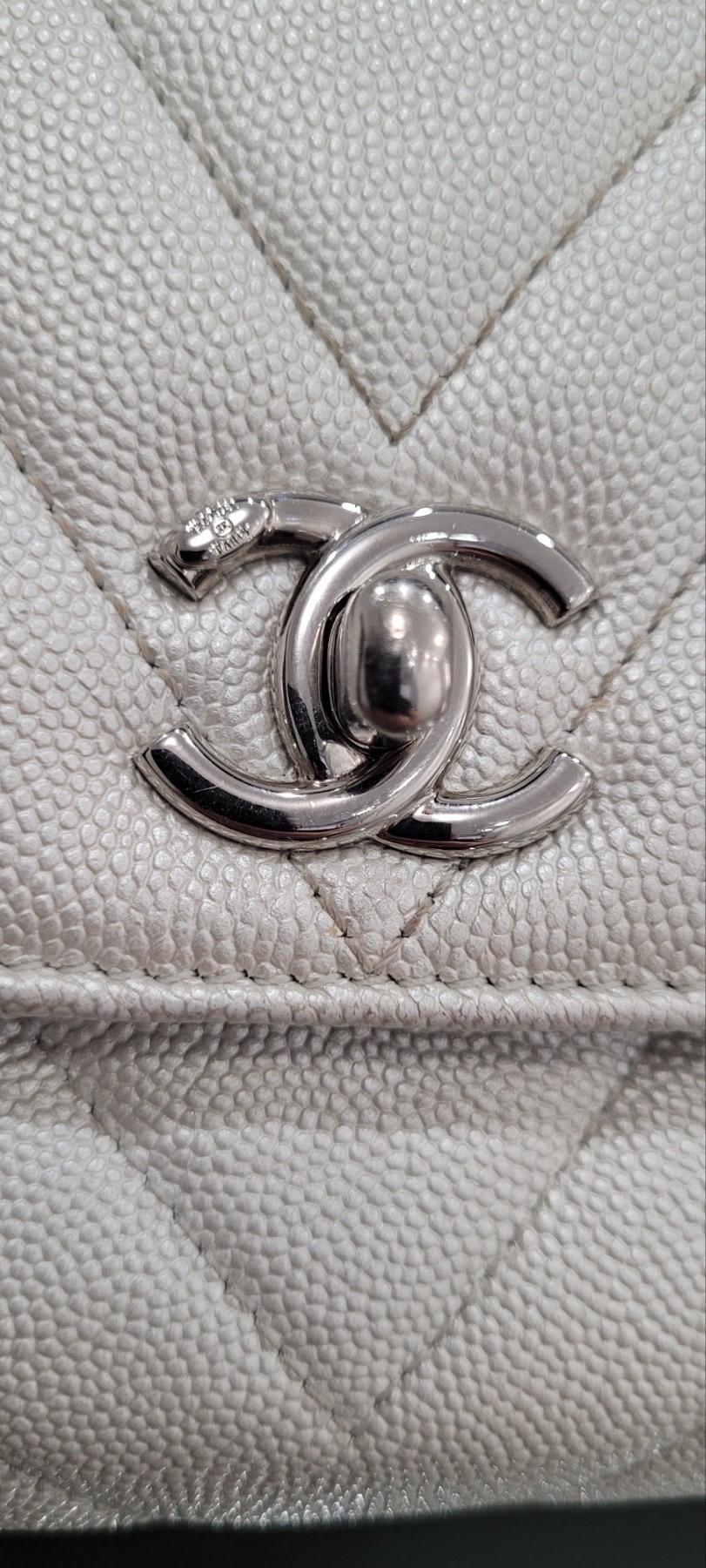 Diese Chanel Coco Handle Tasche ist ein schönes und zeitloses Stück. 

Er ist aus perlweißem Kaviarleder mit Chevron-Steppung gefertigt und strahlt Eleganz und Raffinesse aus. 

Die kleine Größe von 24 cm ist perfekt für den täglichen Gebrauch,