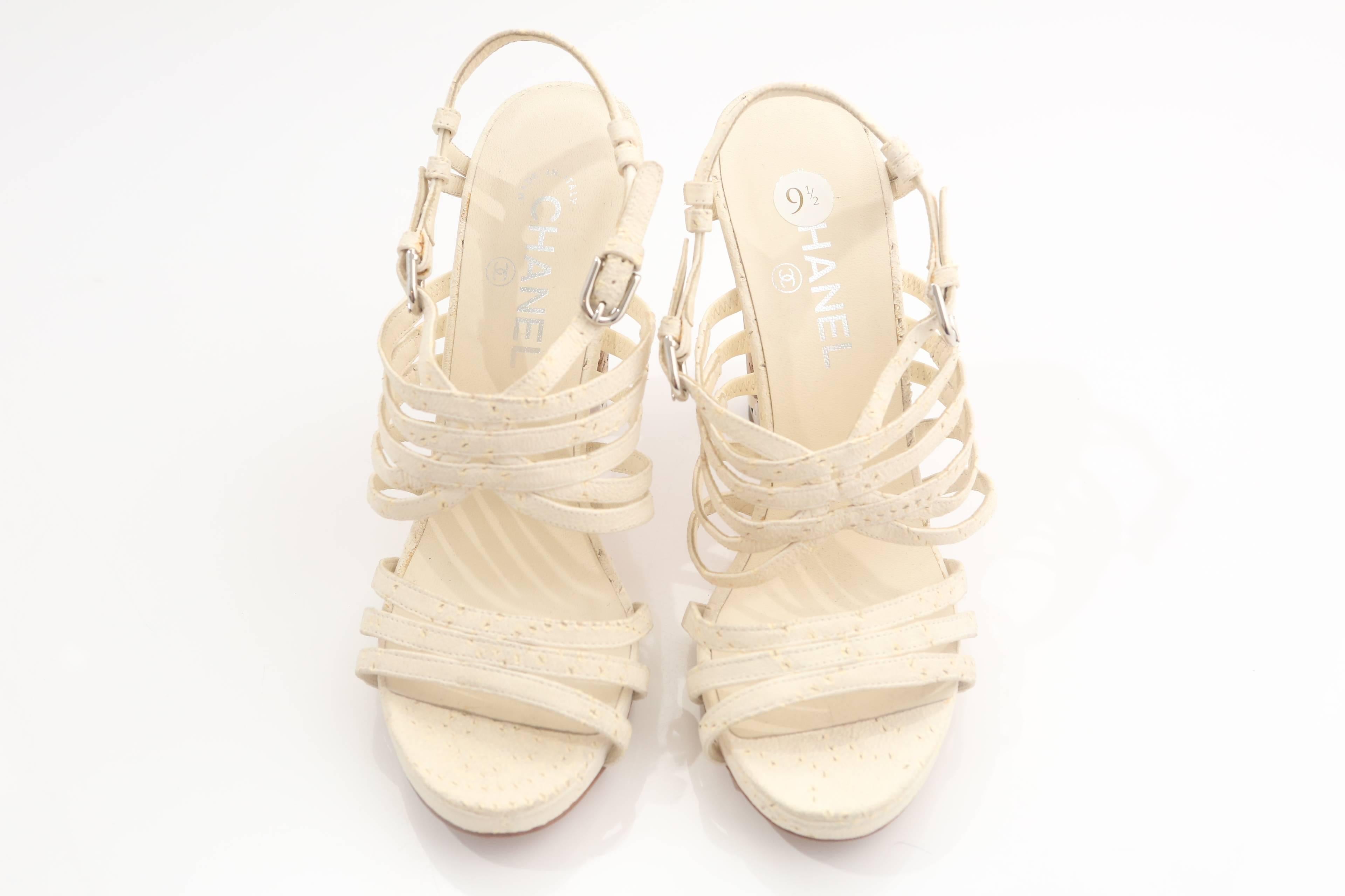 Chanel white leather sandals with cork heel and classic chain design.  Double buckle closure.

