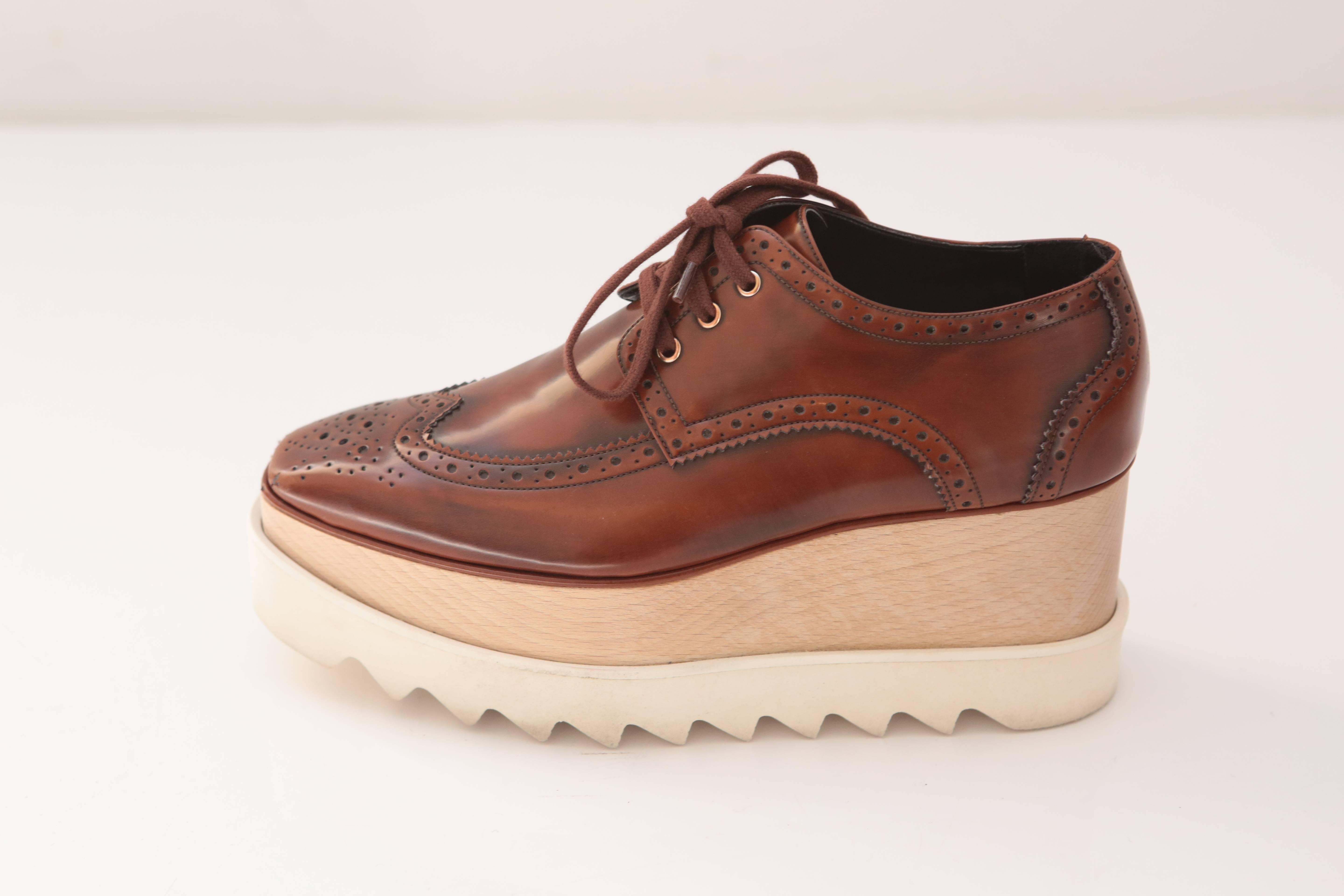 Faux-leather Oxford-style design platform, featuring a sustainable wood and white sharktooth rubber sole.