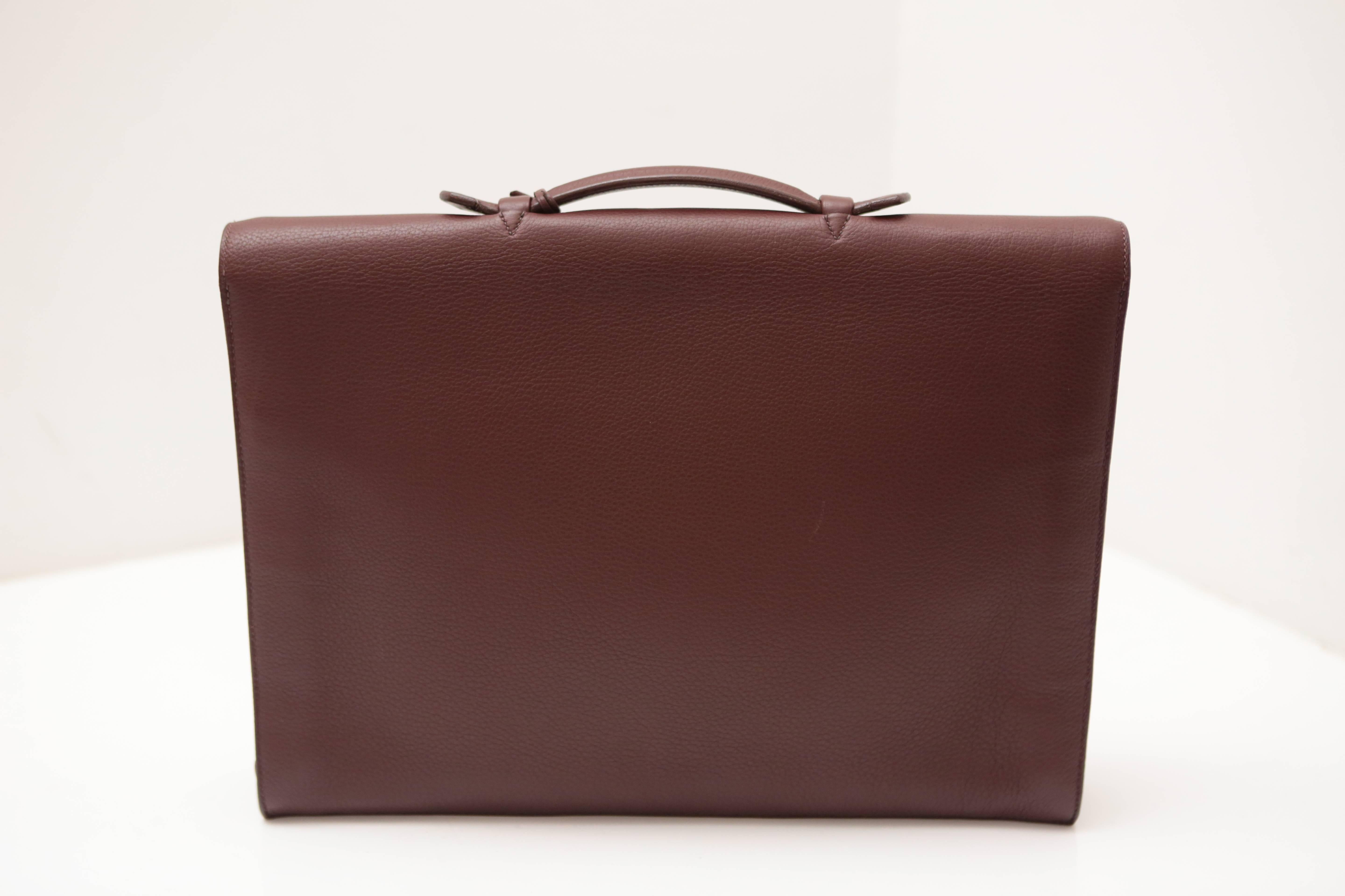 Deep brown leather briefcase with complimentary stiching to match. Silver hardware and a sliding lock clasp with keys. Leather tri-fold interior.  The perfect piece for the sophisticated professional. Handle Drop: 1.5