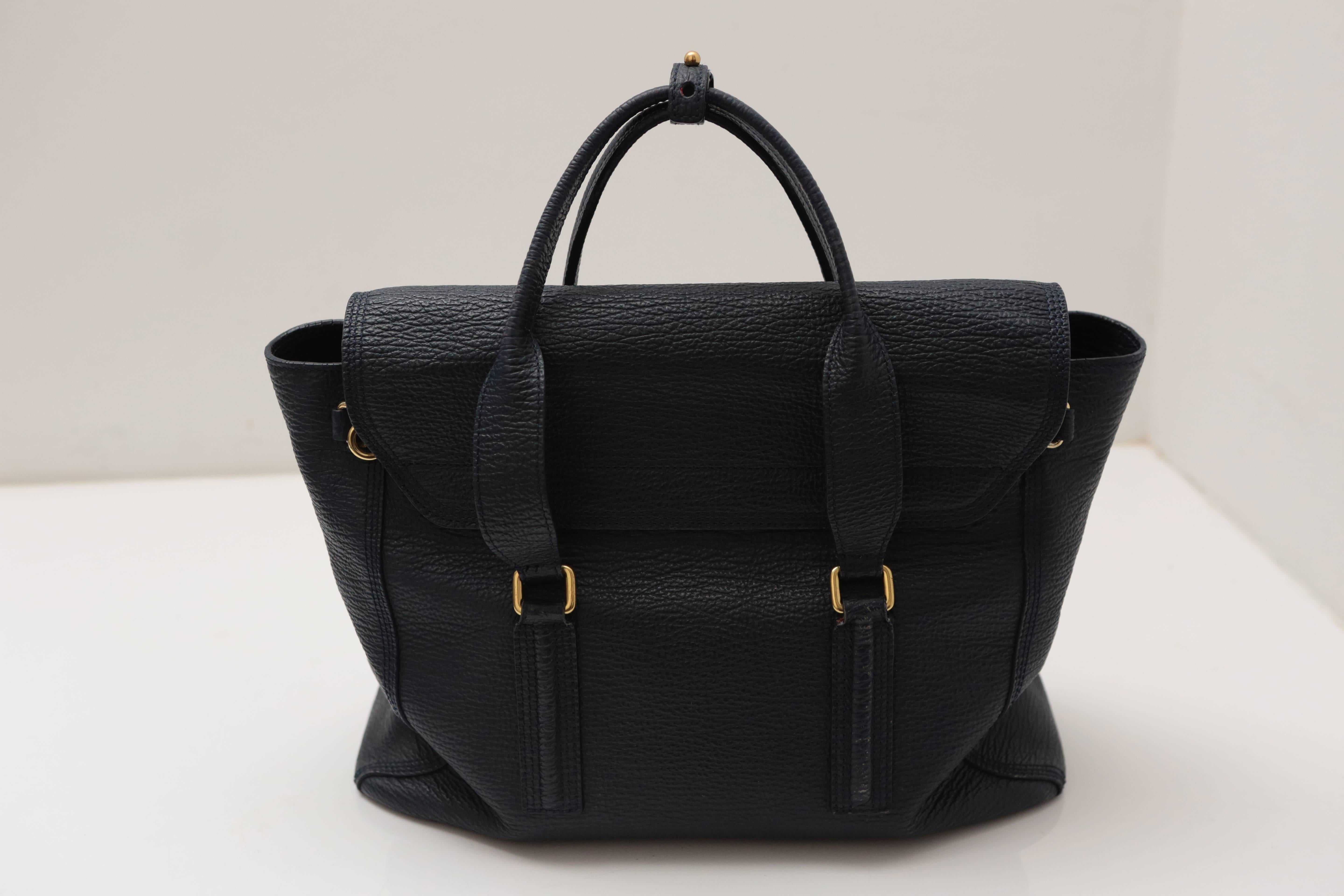 Textured navy leather adorns this medium-sized satchel, featuring a detachable cross-body strap and zipper gussets that open into a fan shape. Gold hardware and a push lock closure complete this staple handbag.