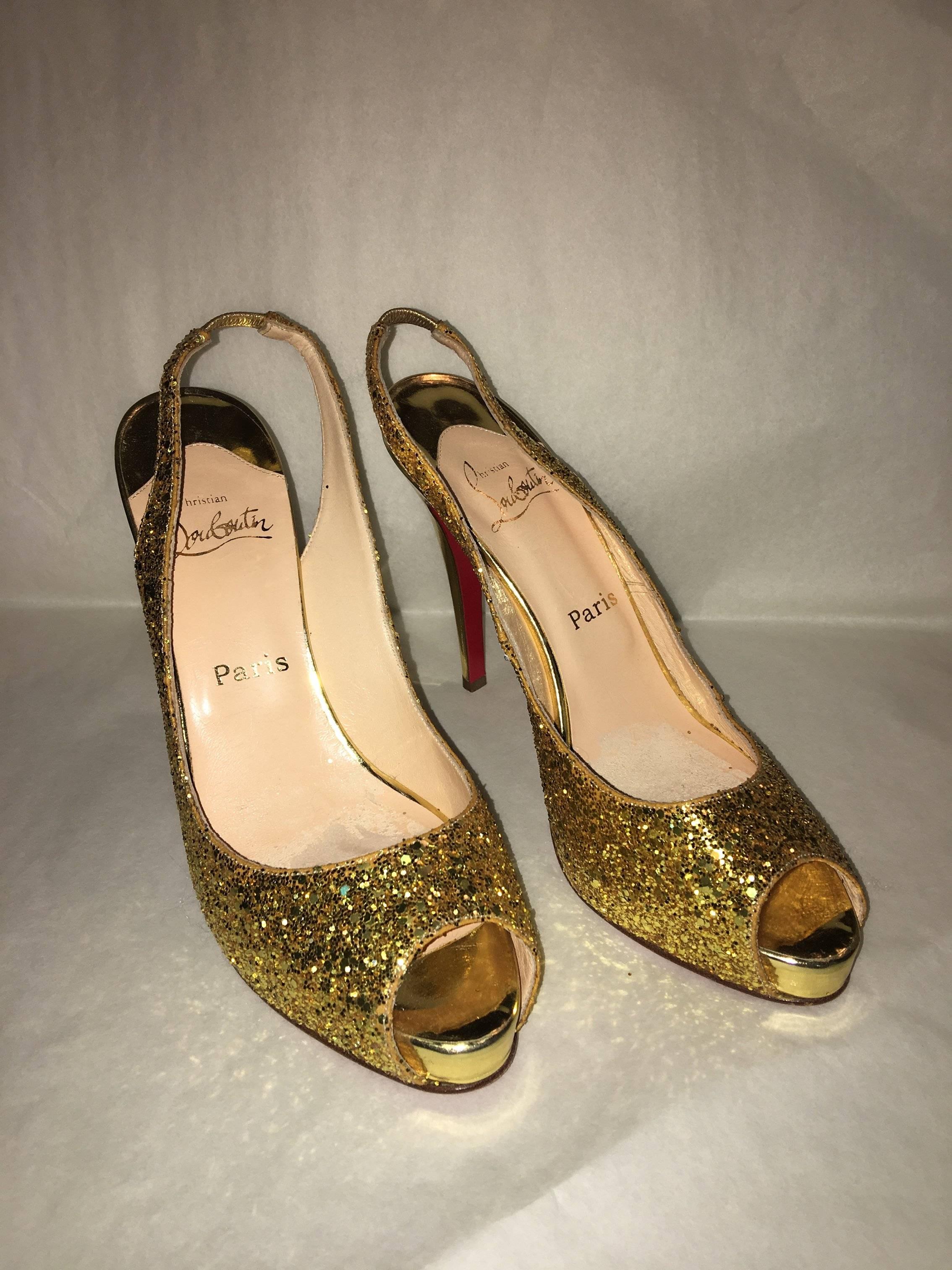 Lightly worn Christian Louboutin Gold Glitter Slingbacks. The highly coveted red bottom heels covered in glitzy gold glitter with a metallic gold heel. 