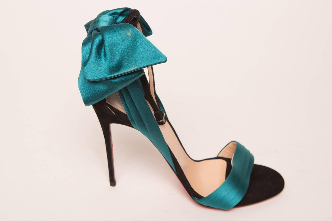 Christian Louboutin teal satin and black high heel sandals with ankle strap and back bow detail.