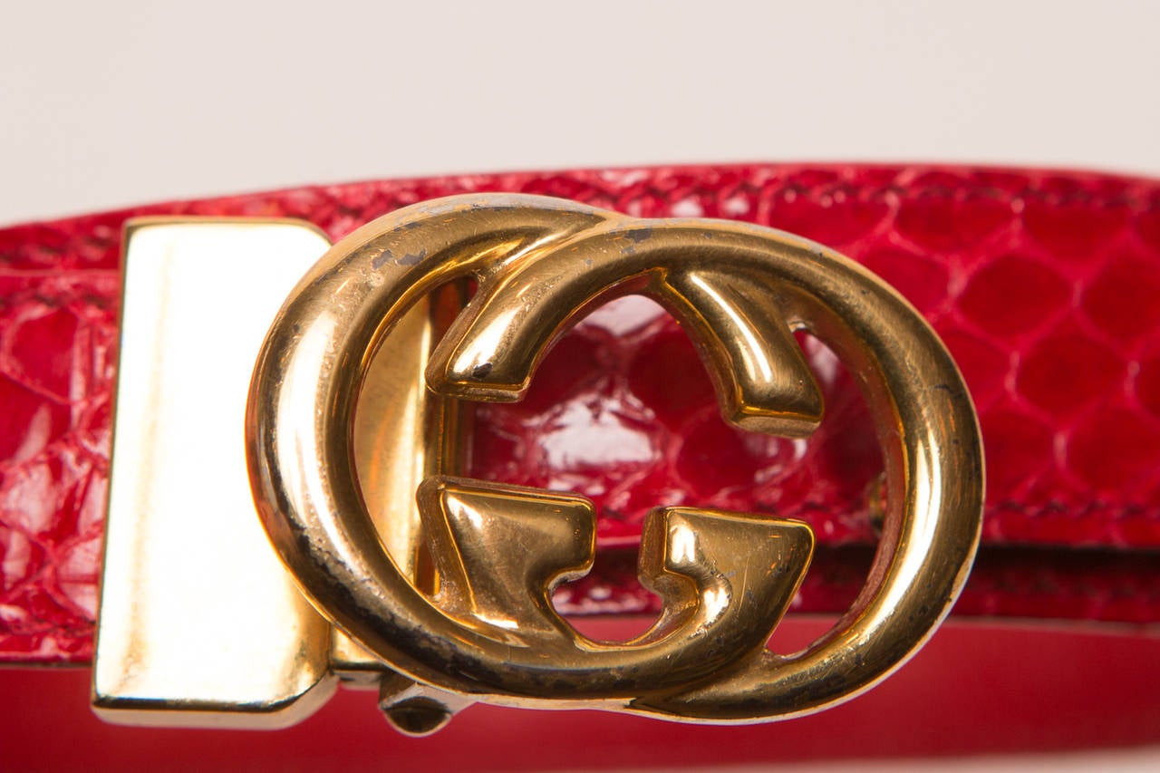 Gucci red snakeskin leather belt, with gold GG logo.