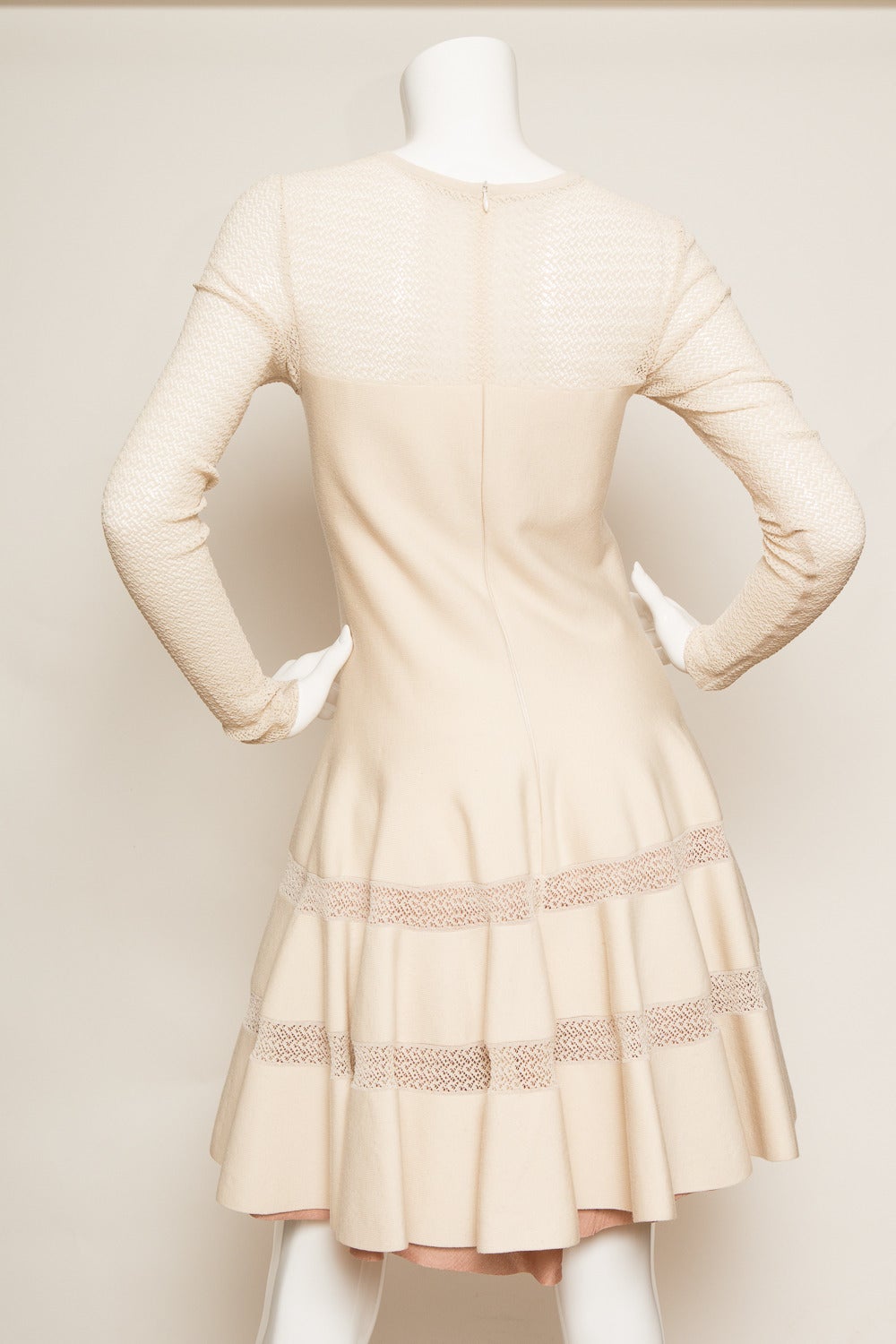 Creme Alaïa long sleeve fit and flare wool dress with textured pattern throughout, pleated trim at skirt and invisible back zip closure.

Sleeve Length: 27