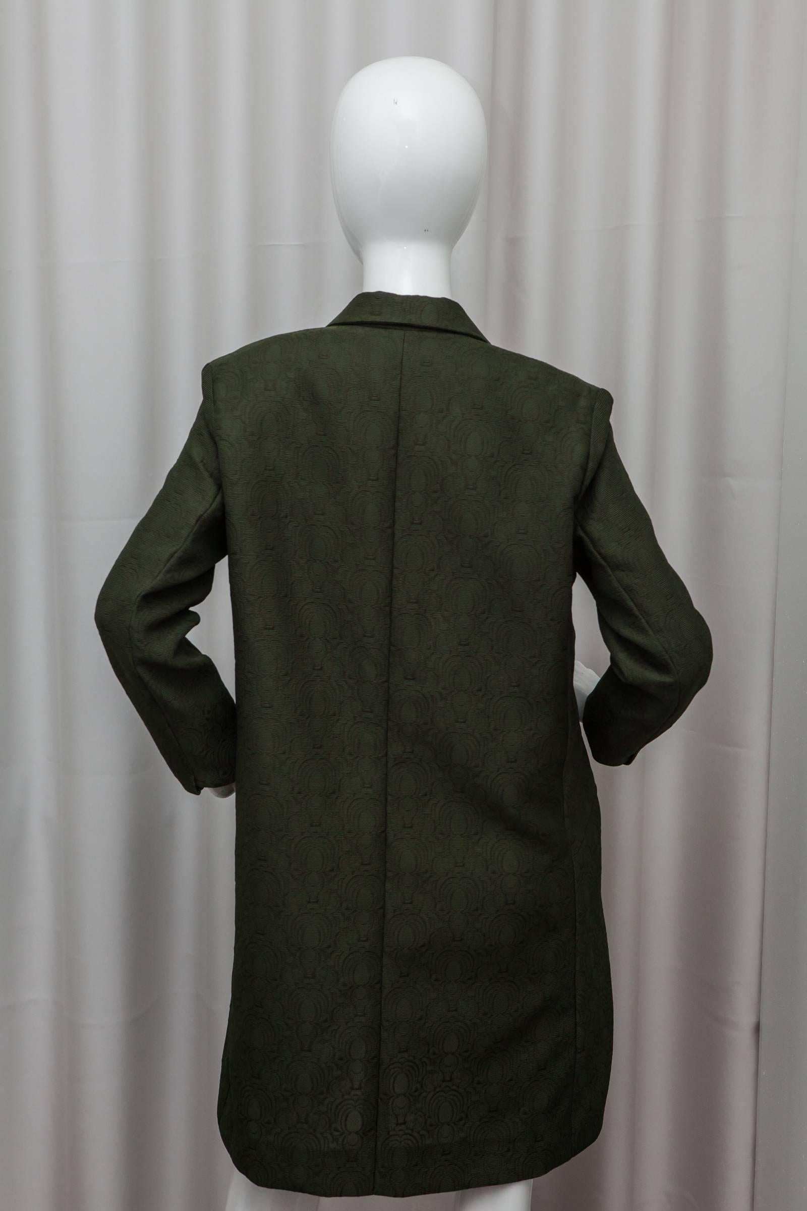 Loden green evening coat with textured pattern and front pockets, button closure.