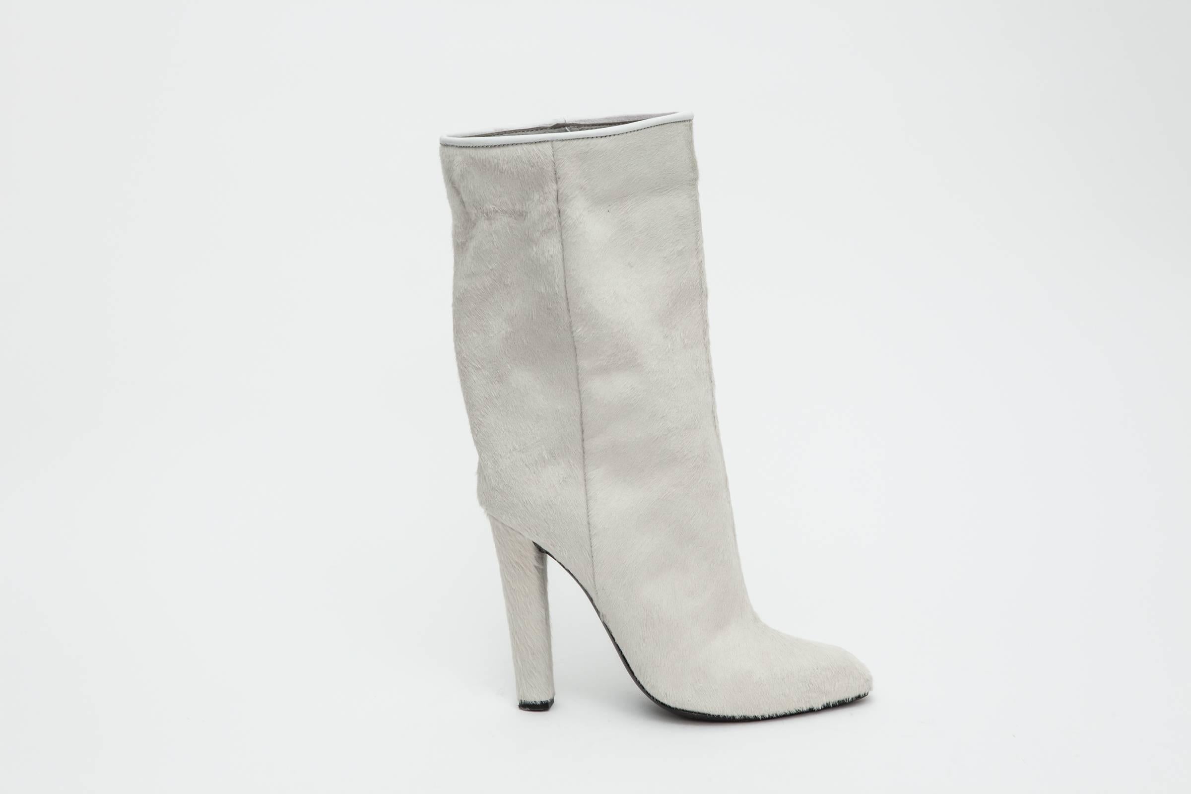 Mid-calf ivory pony skin boots with 4" heel and inner zip closure.