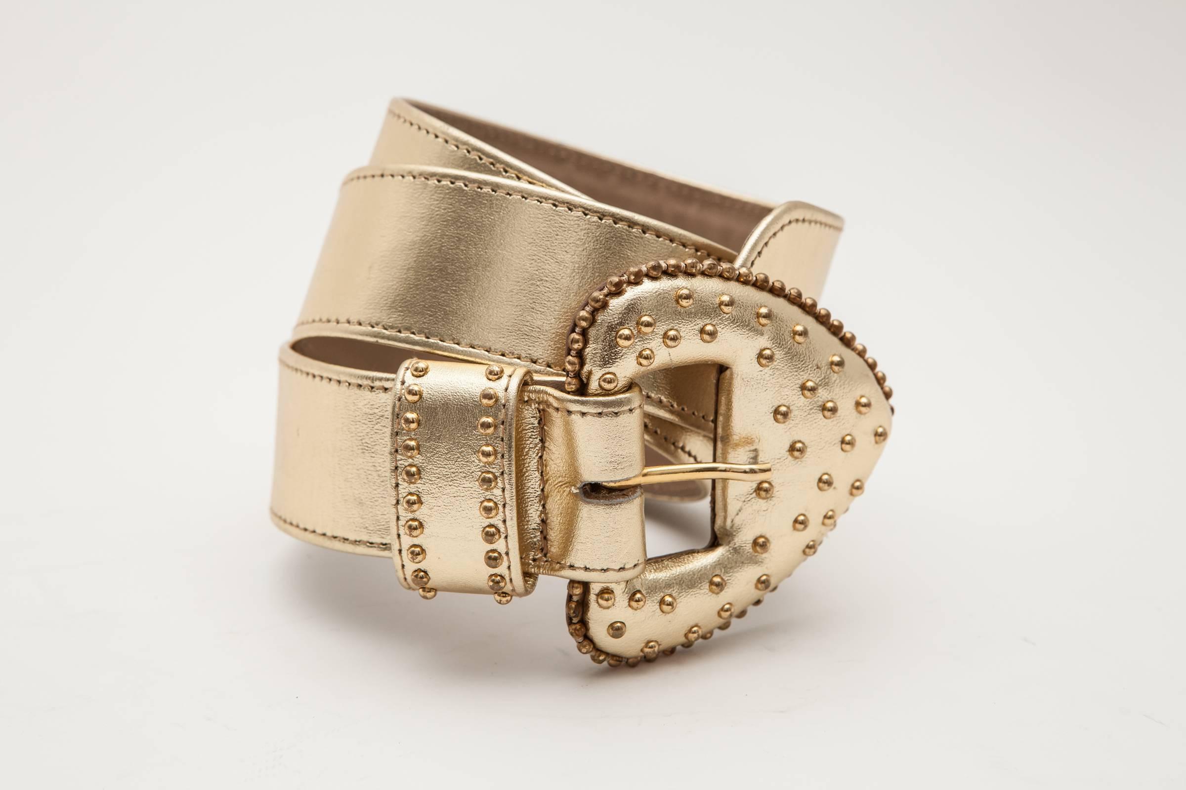 Gold leather belt with large studded buckle.