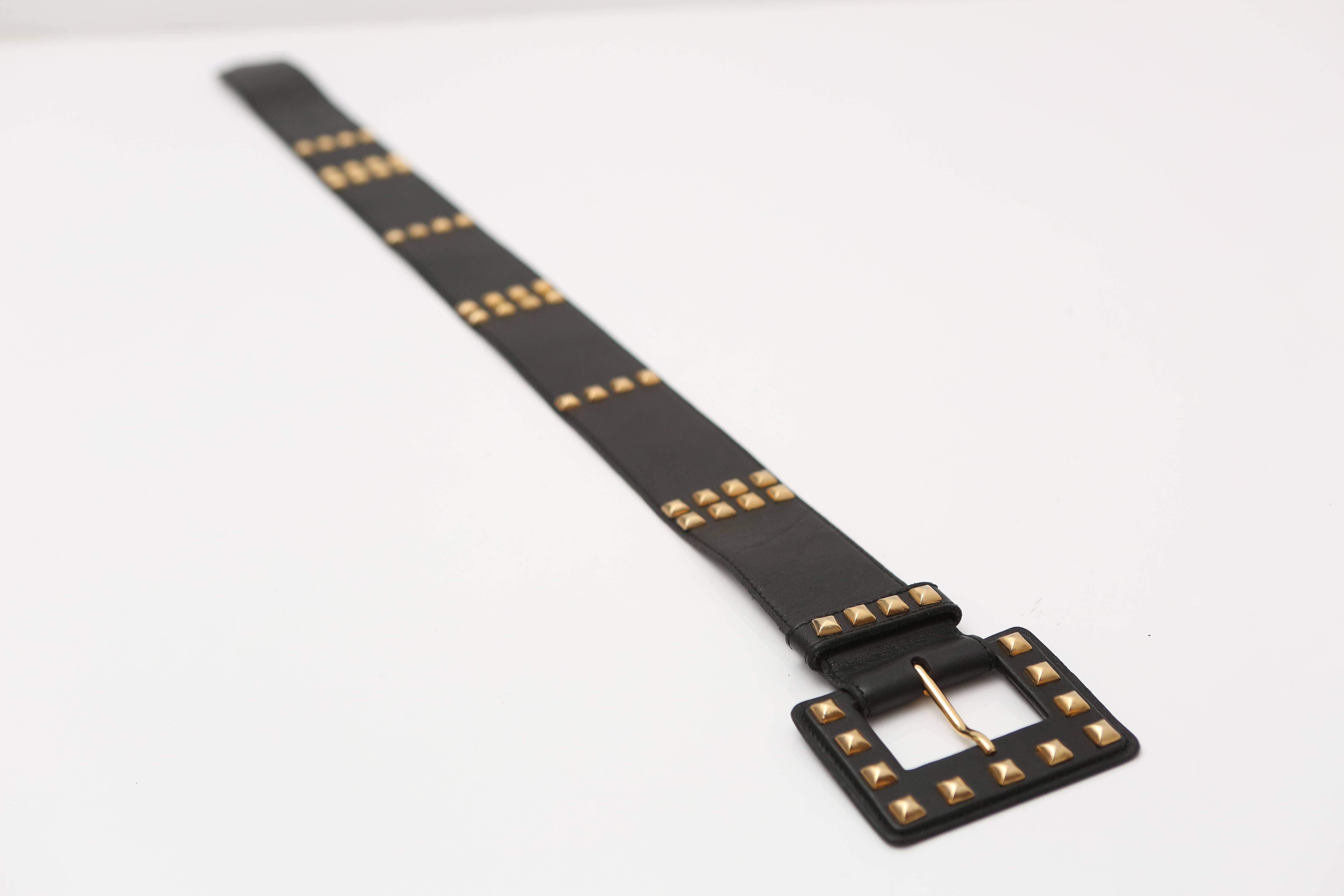 Black leather belt with gold stud detail.