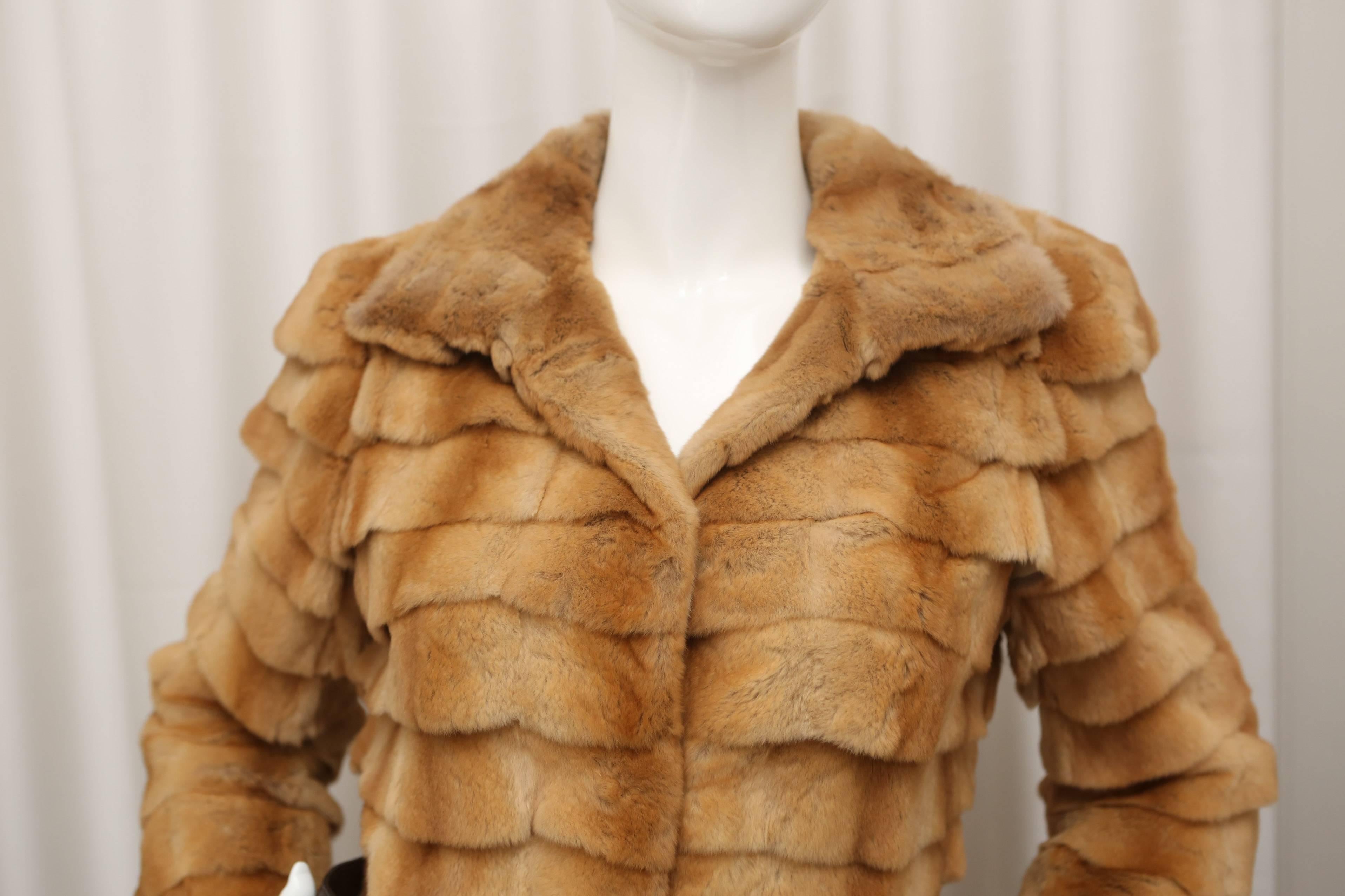 Blond fur coat fur coat with brown leather belt.