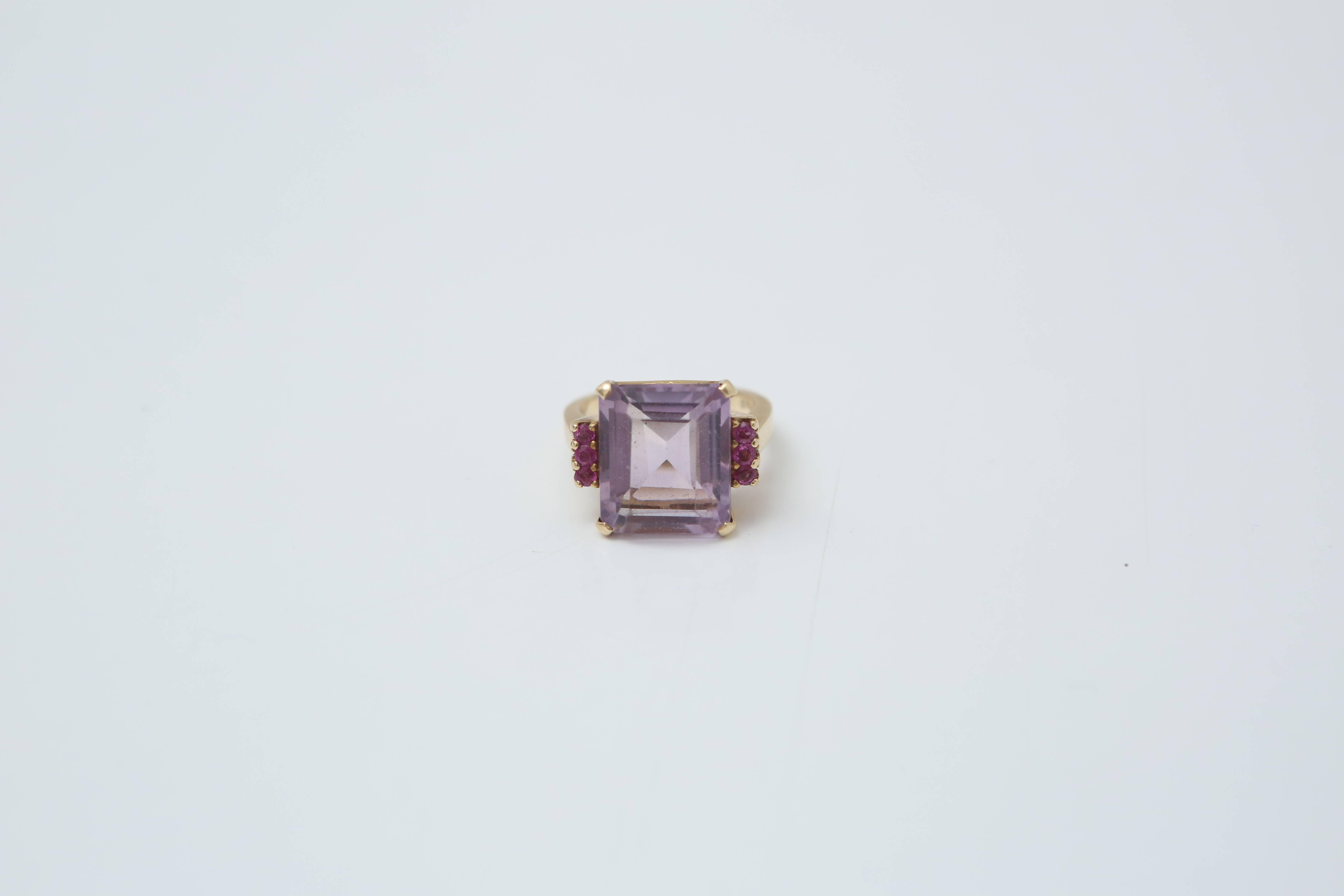 Cocktail ring with approx. 20 carat emerald cut Amethyst with six small rubies on the sides.  
