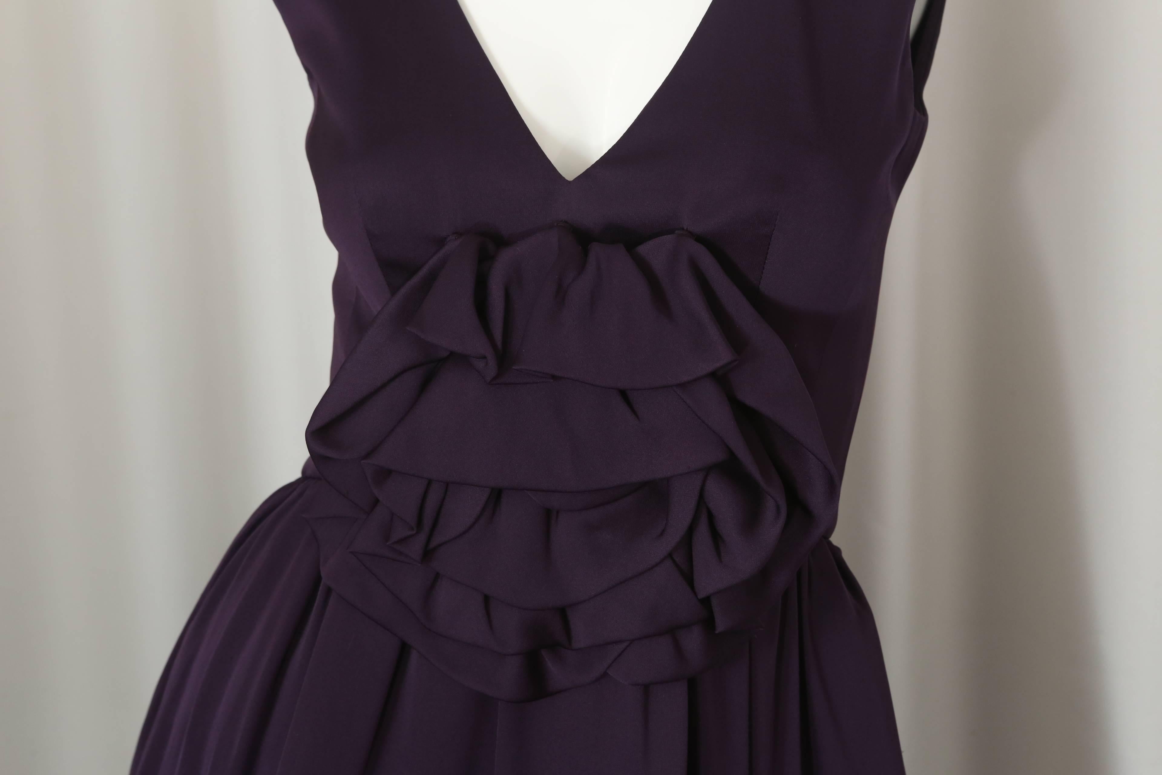 Asprey sleeveless purple cocktail dress with v-neck, removable flower & back zipper closure.