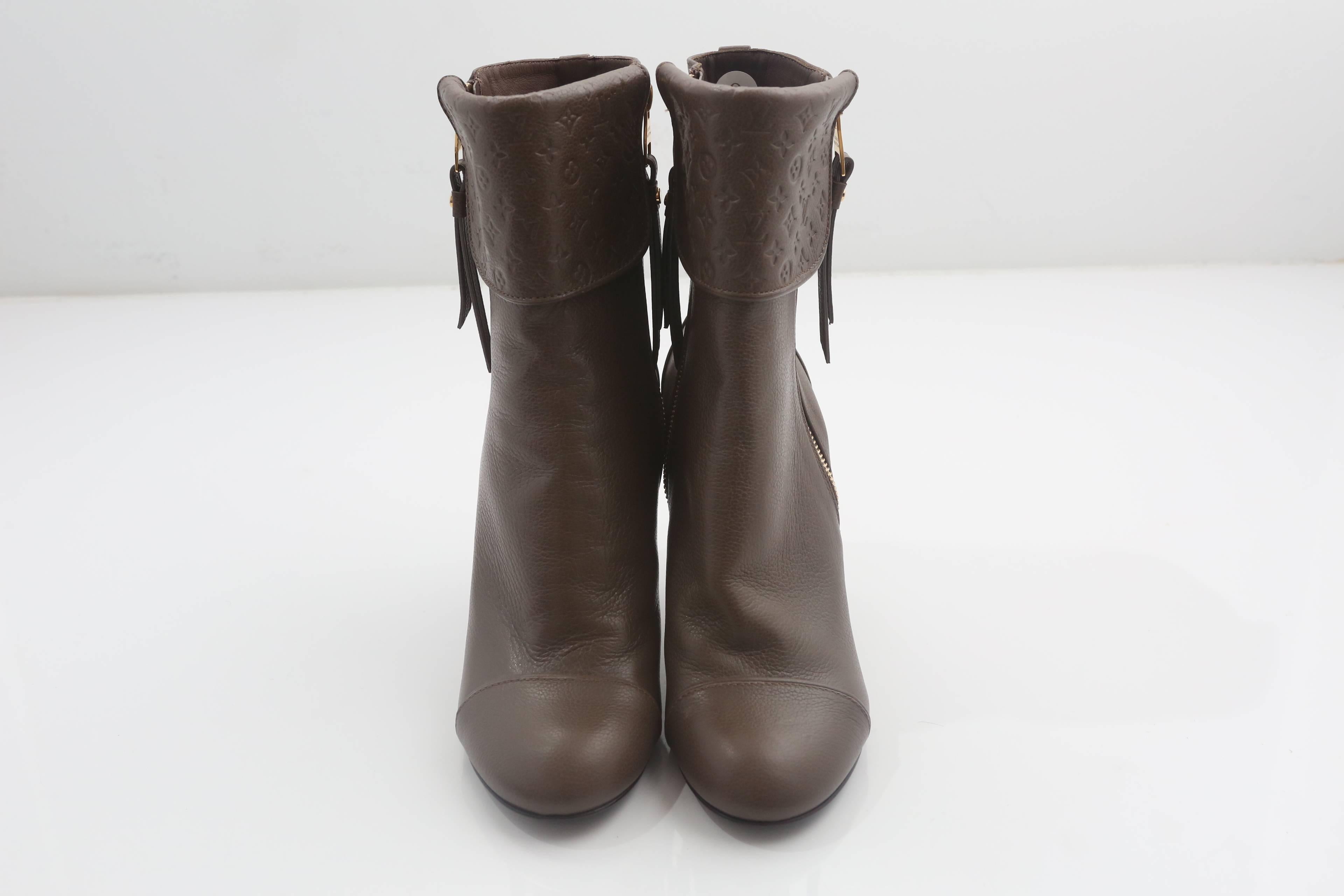 Louis Vuitton brown leather booties with double side zipper, tonal embossed monogram logo at front foldover flap.